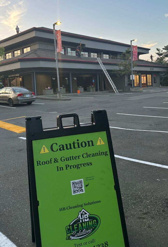 Caution sign saying roof and gutter cleaning in progress with HB Cleaning Solutions logo on it