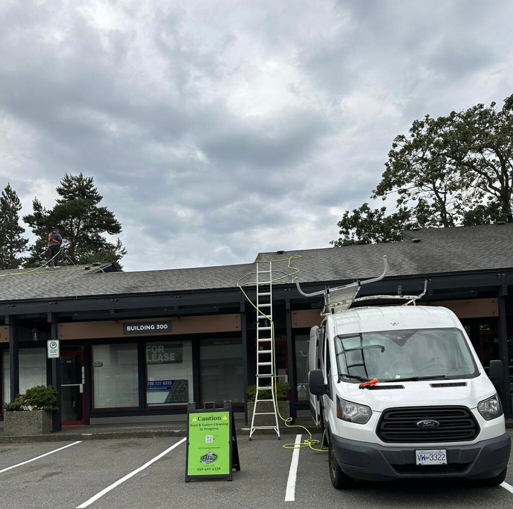 HB Cleaning Solutions work van parked in front of building with ladder going to roof