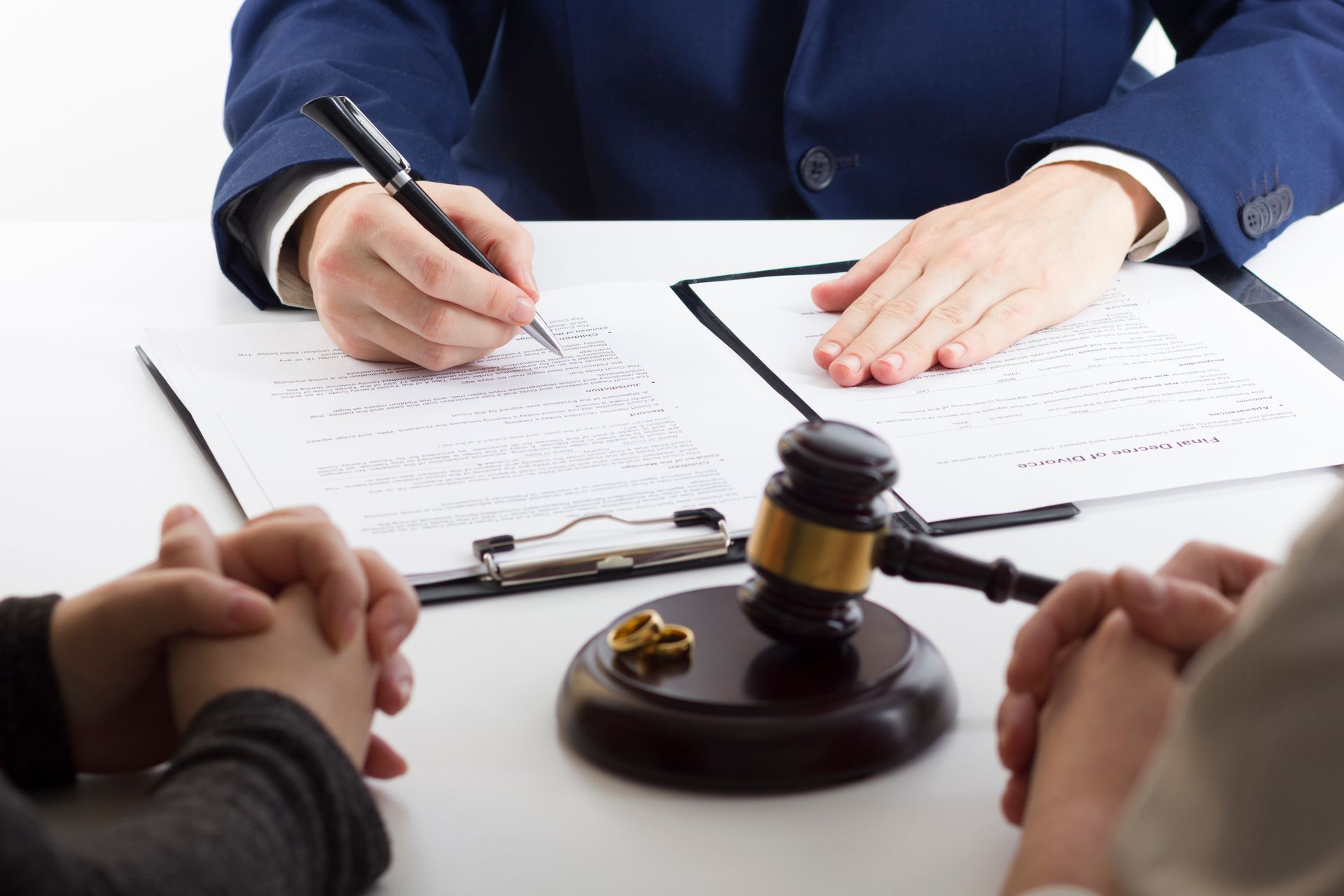A man is sitting at a table with a clipboard and a gavel.