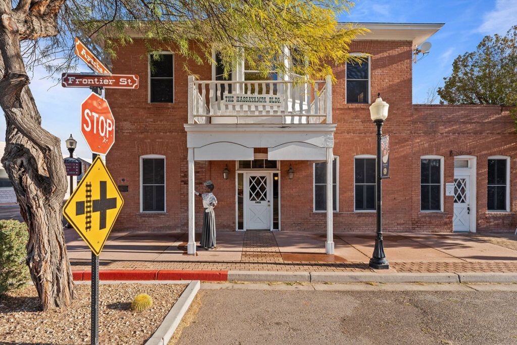 Brick building with balcony and stop sign at an intersection.