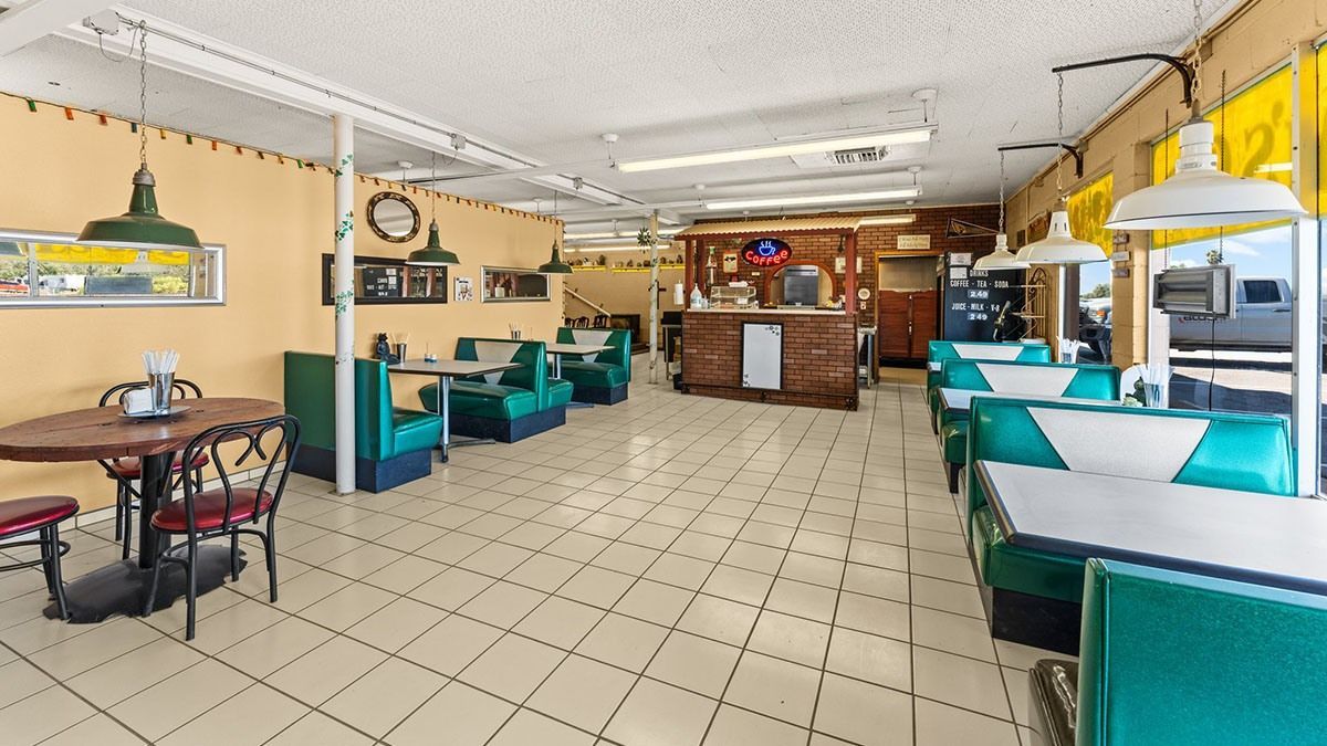 Interior of a diner with turquoise booths, tile floor, and a wooden counter.