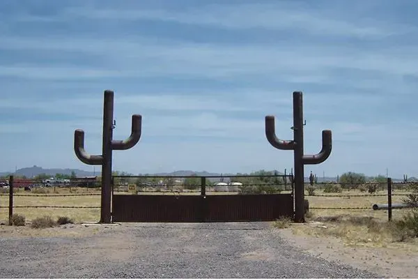 Desert home exterior at sunset, surrounded by cacti and rock landscaping.