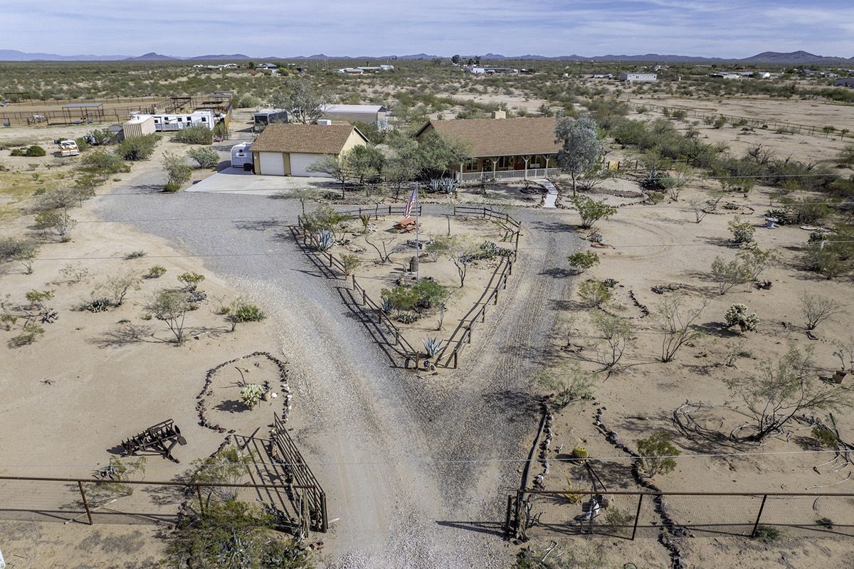 An aerial view of a desert home with a gravel driveway shaped into a heart.
