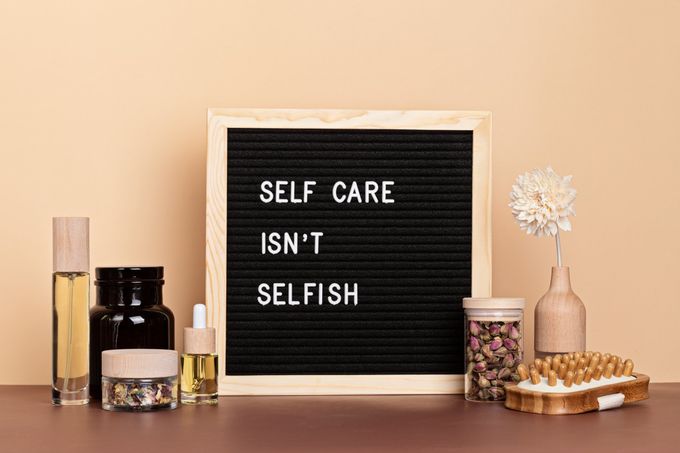 self care isn't selfish letter board with beauty products placed around