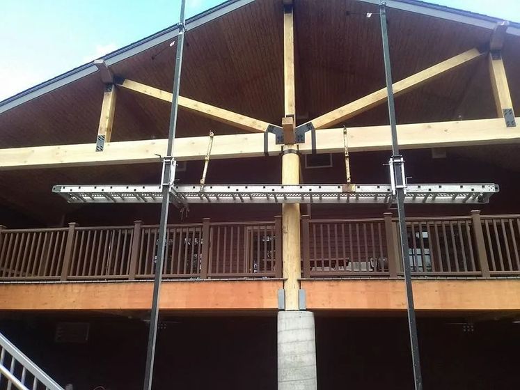 A ladder is hanging from the roof of a building