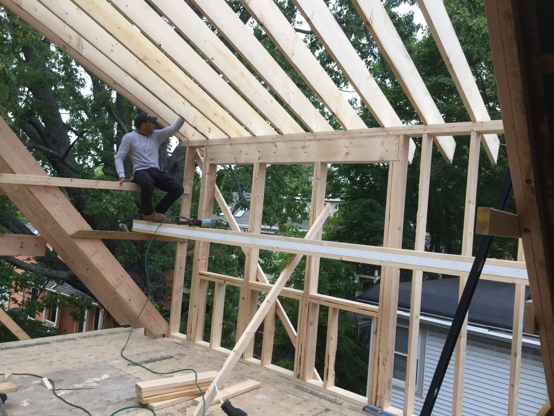A man is sitting on top of a wooden structure.