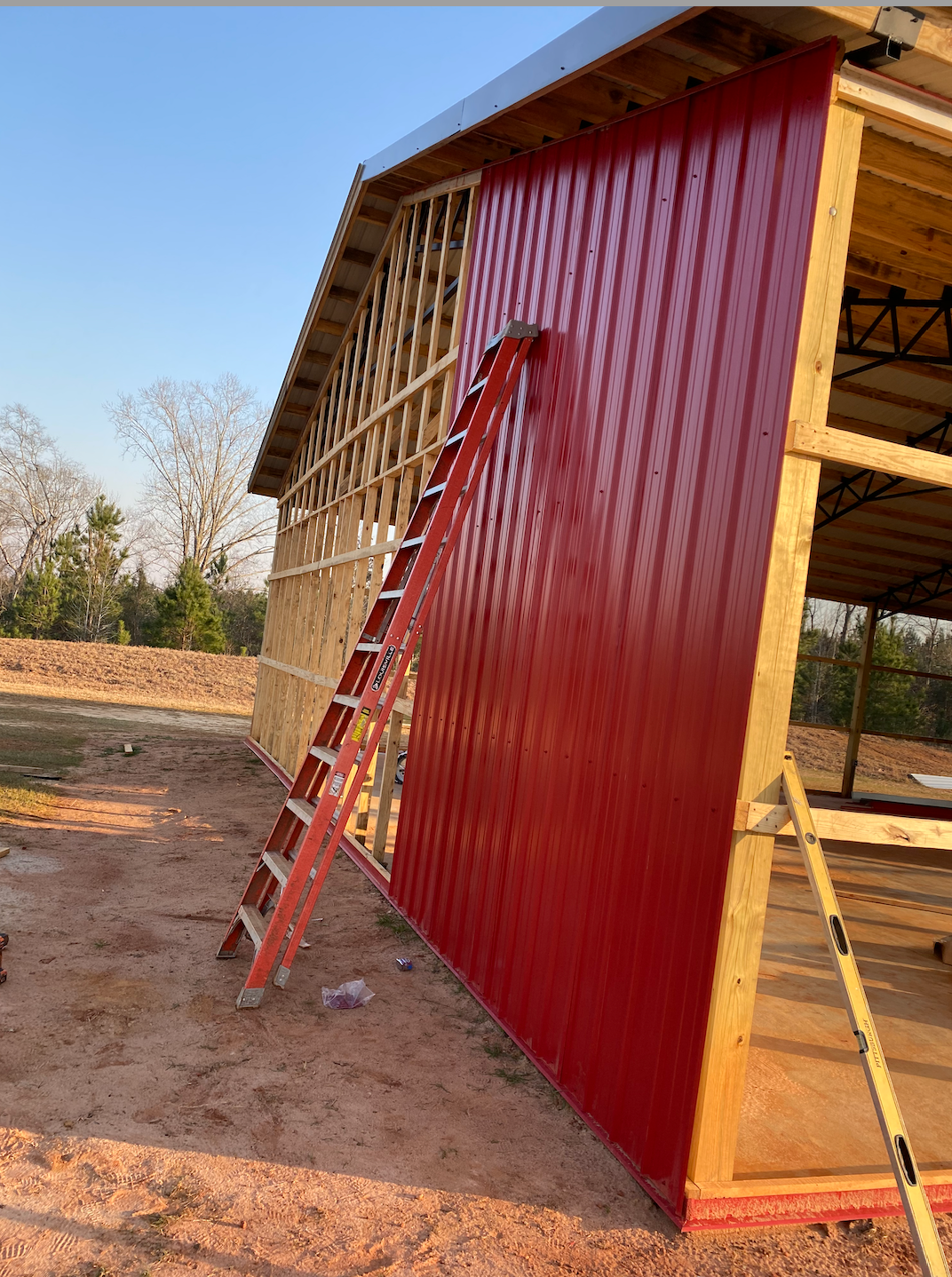 A red ladder is leaning against the side of a building.