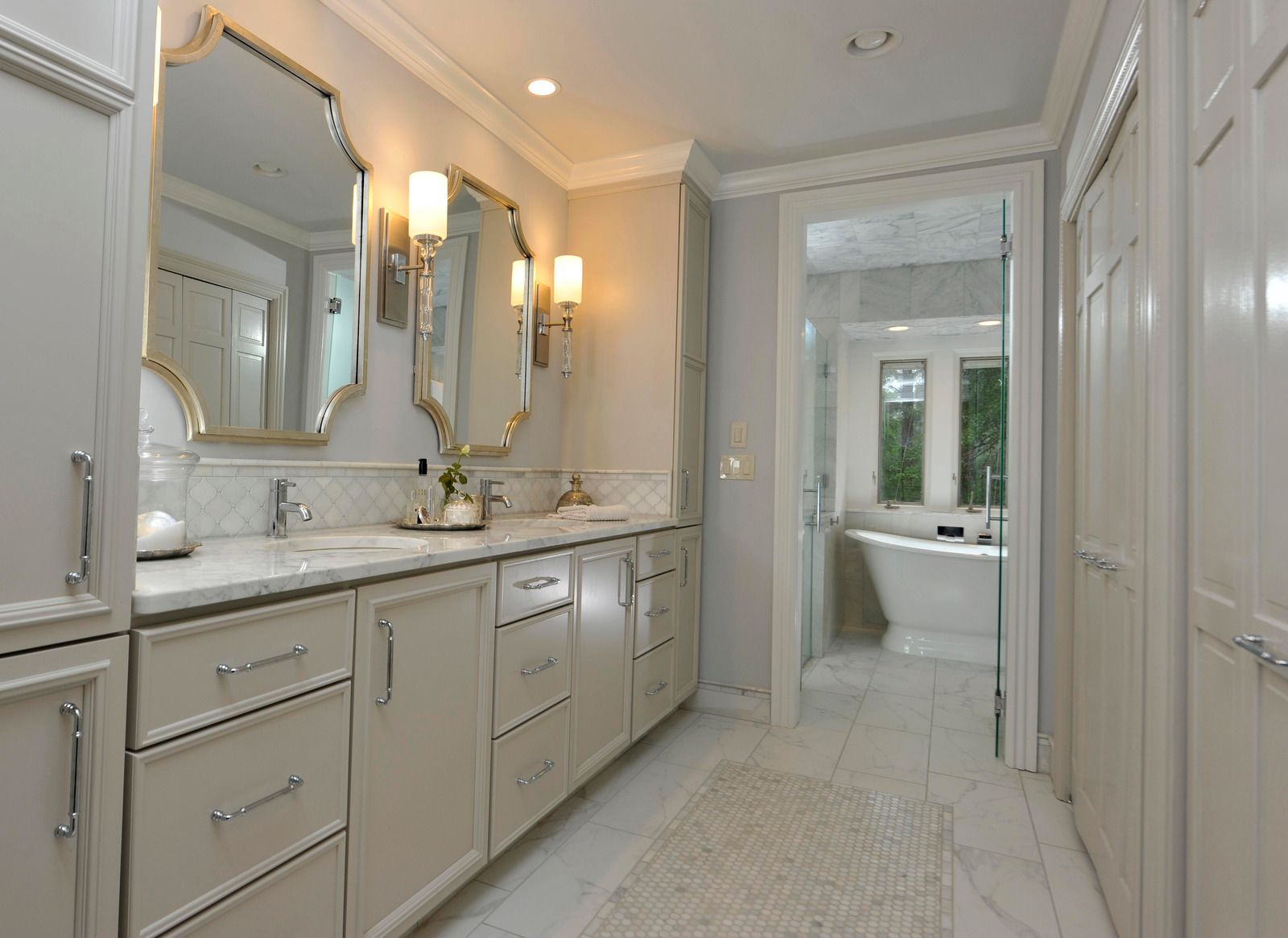 A bathroom with two sinks , two mirrors and a bathtub.