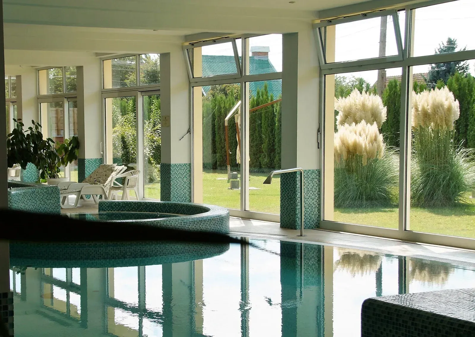 A large indoor swimming pool with lots of windows
