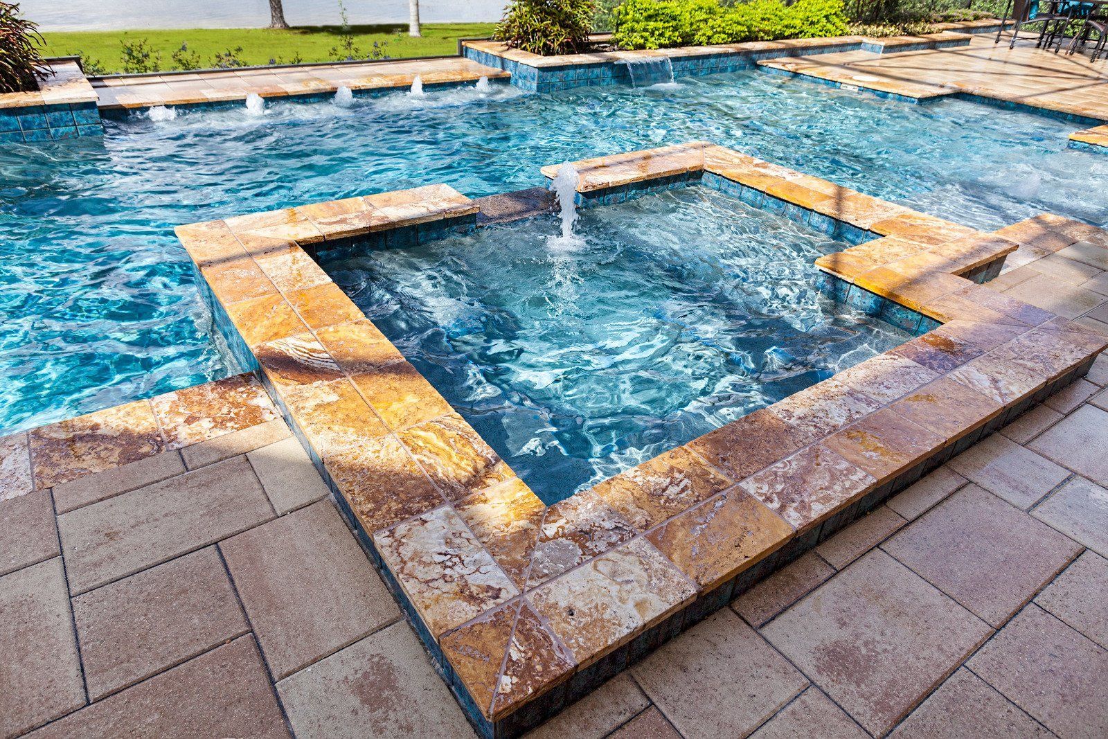 A large swimming pool with a fountain in the middle of it.