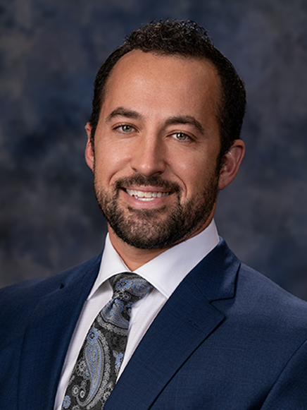 A man in a suit and tie is smiling for the camera.