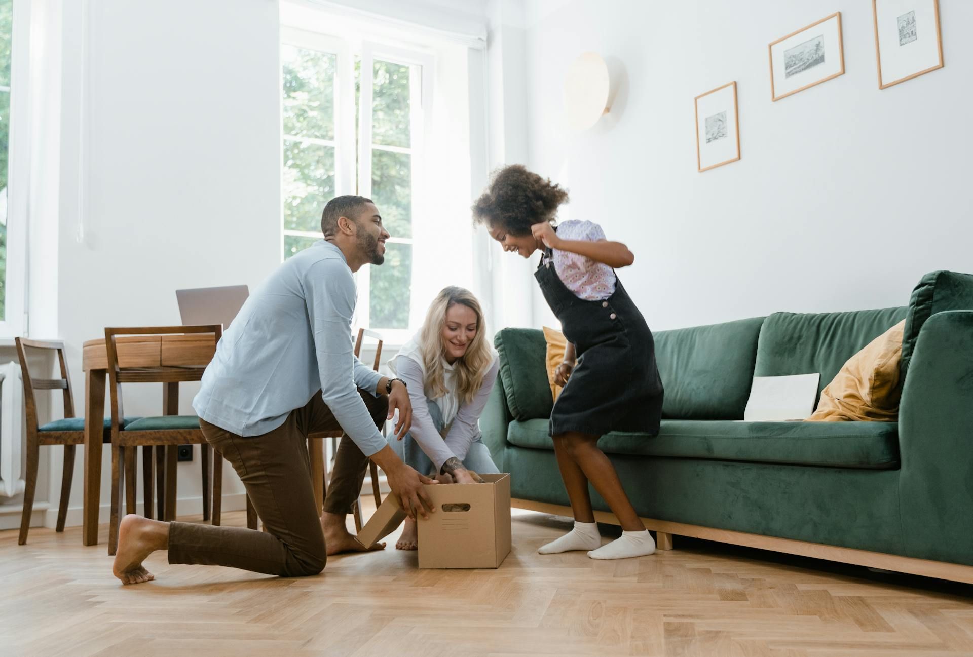 A family is playing with boxes in a living room.