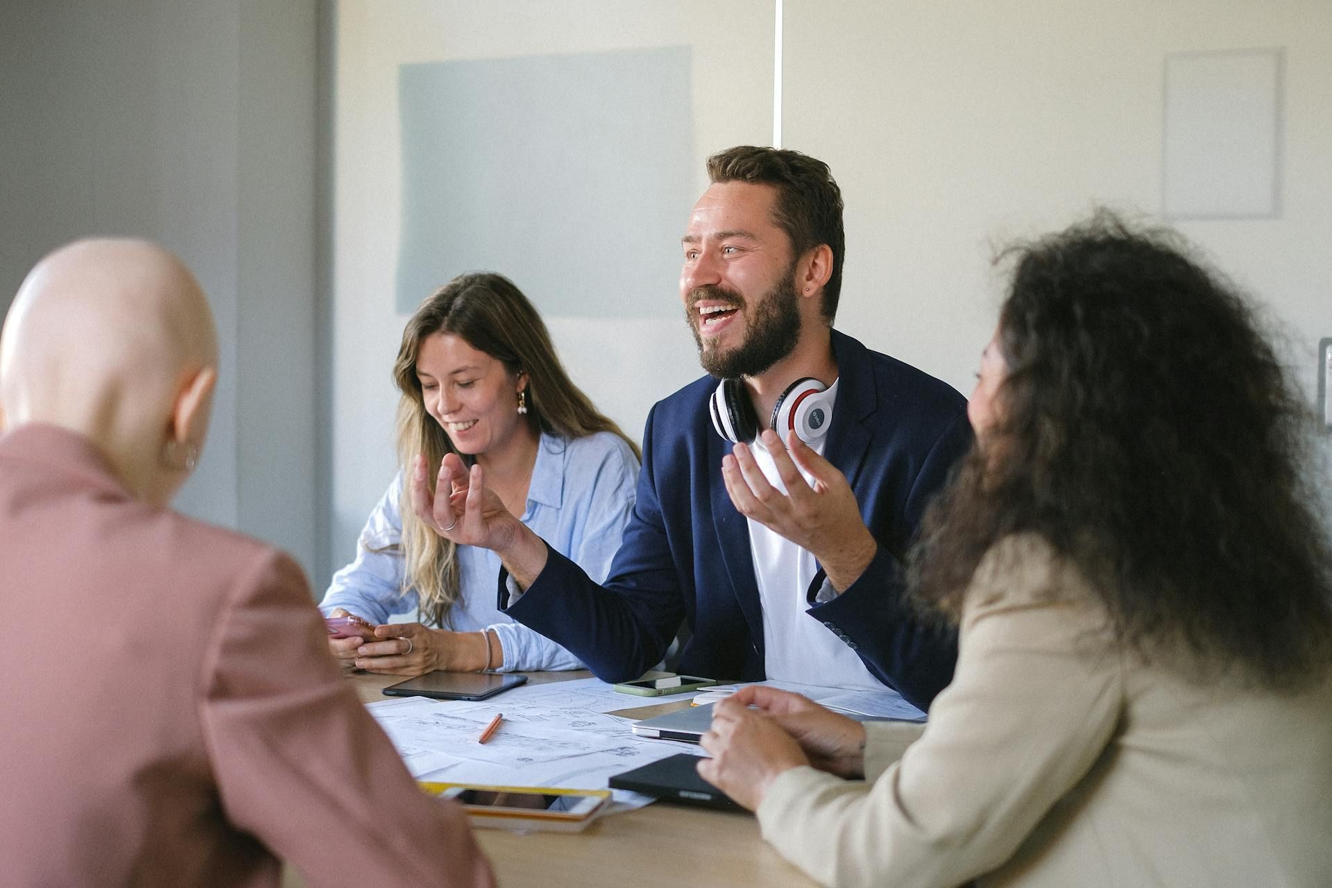 A group of people are sitting around a table having a meeting.