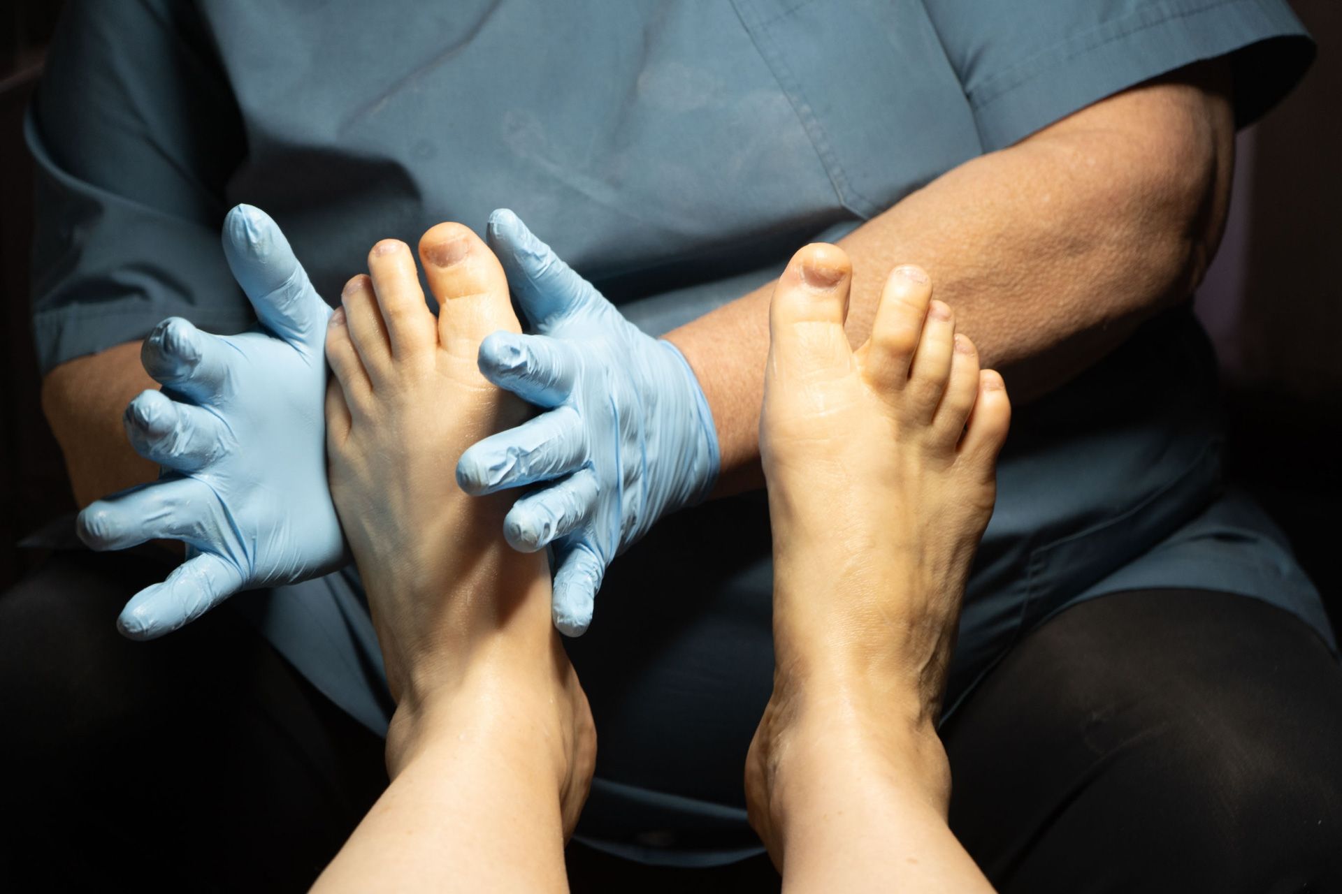A person 's bare feet are standing on a wooden floor.