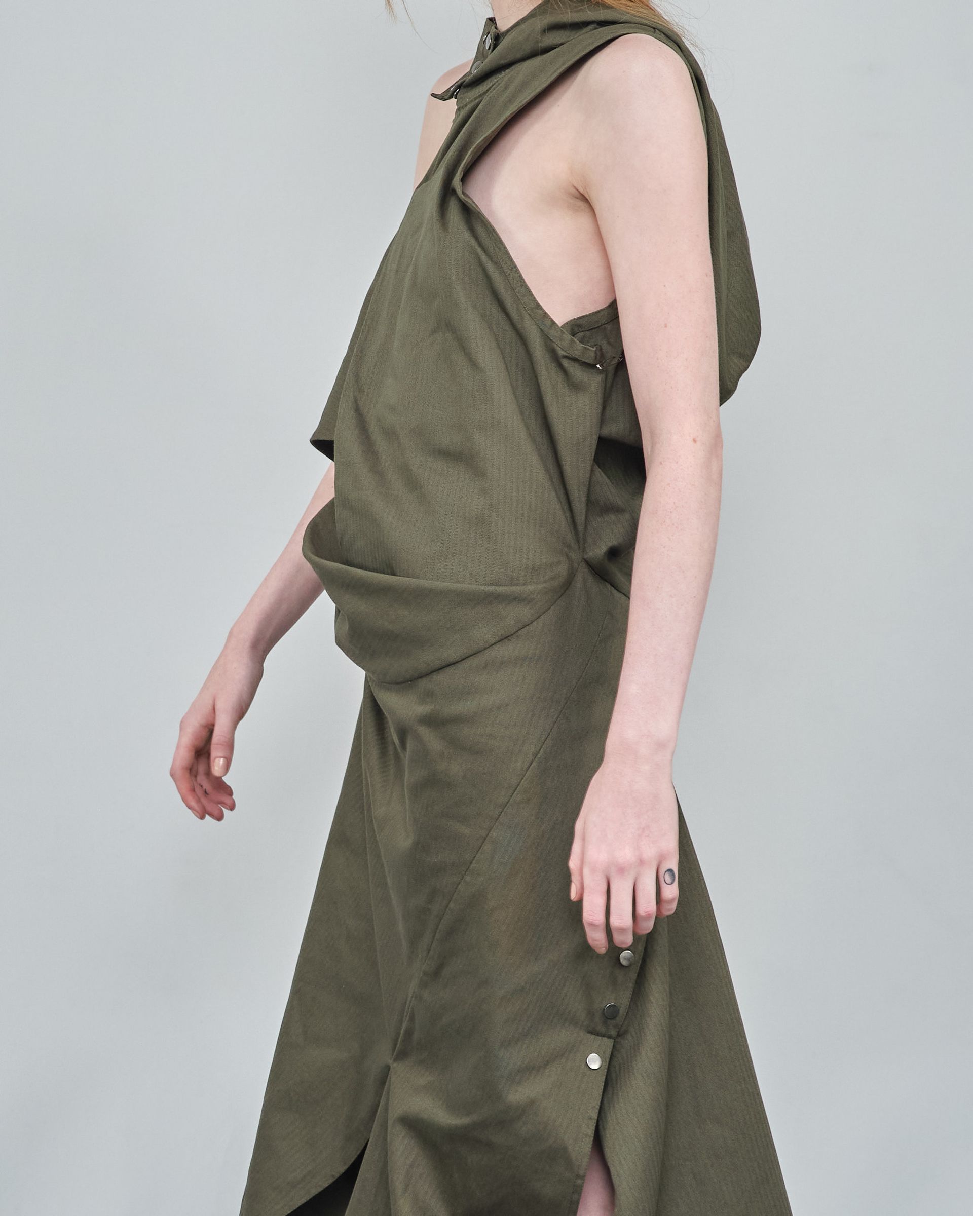 A woman in a green dress is standing on a white background