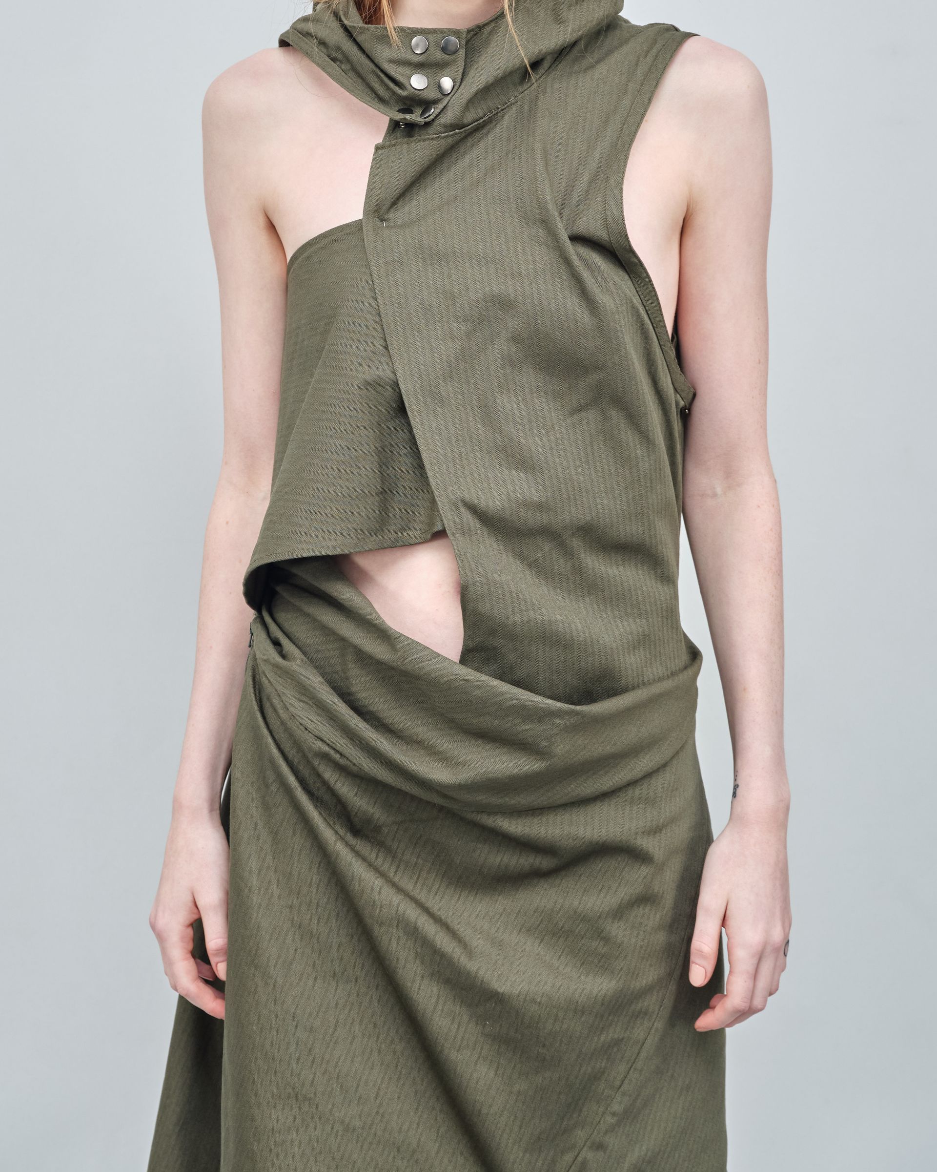 A woman is wearing a green dress with a hood