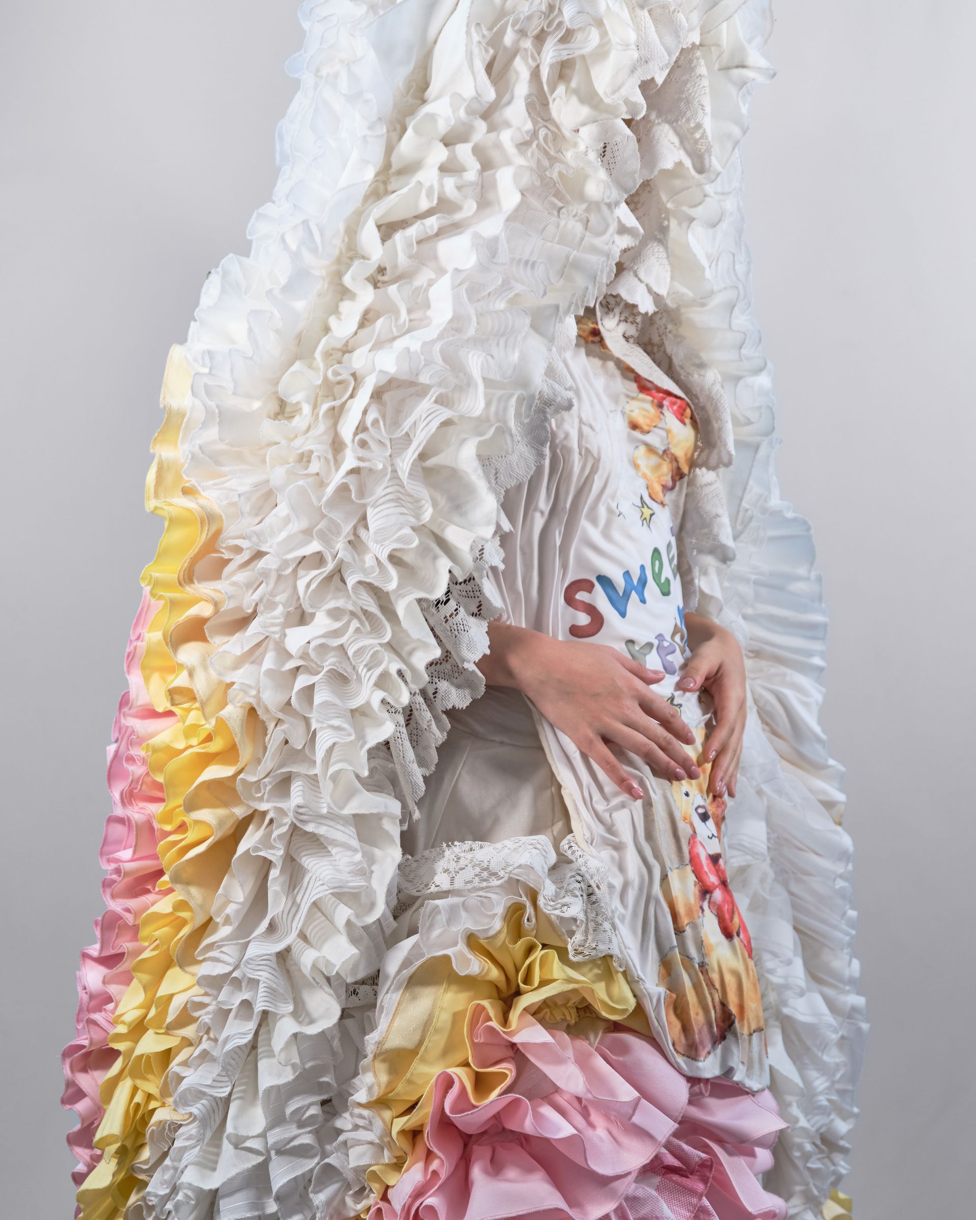 A woman is wearing a white dress with ruffles and a shirt that says sweet on it.