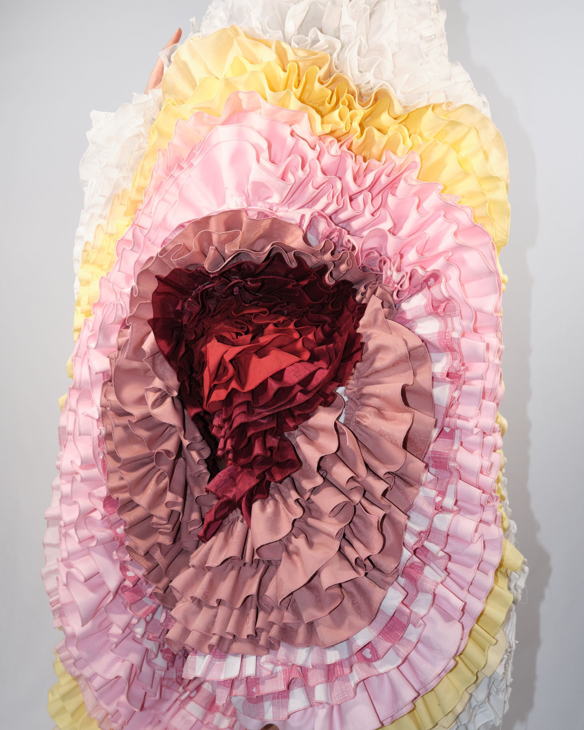 A woman is wearing a white dress with ruffles and a teddy bear on it.