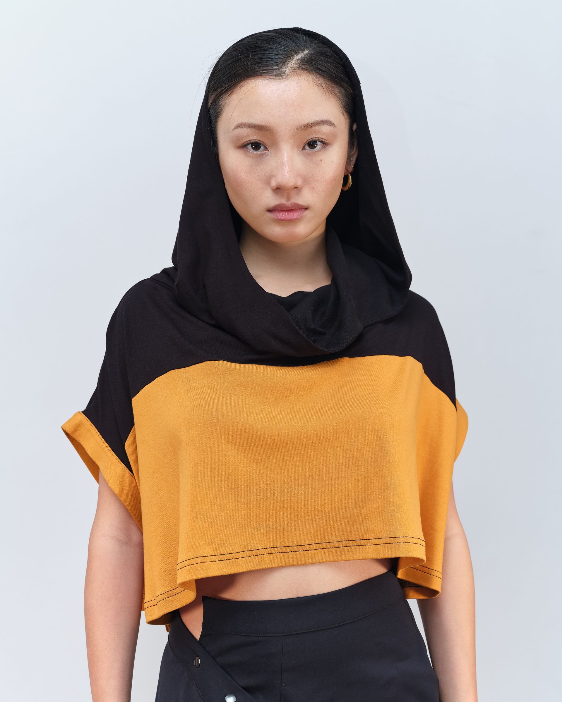 A woman wearing a black and yellow crop top