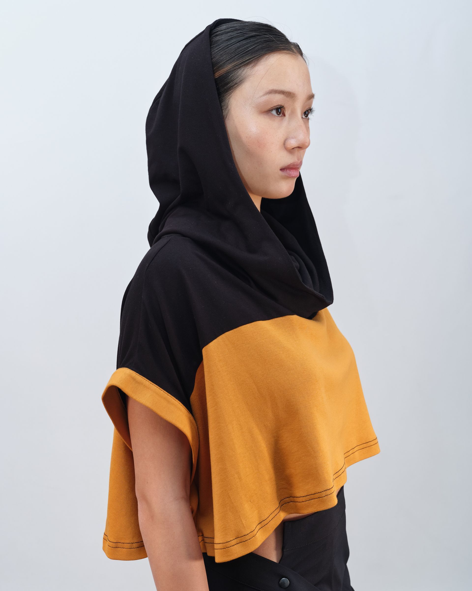 A woman wearing a black and yellow scarf around her neck