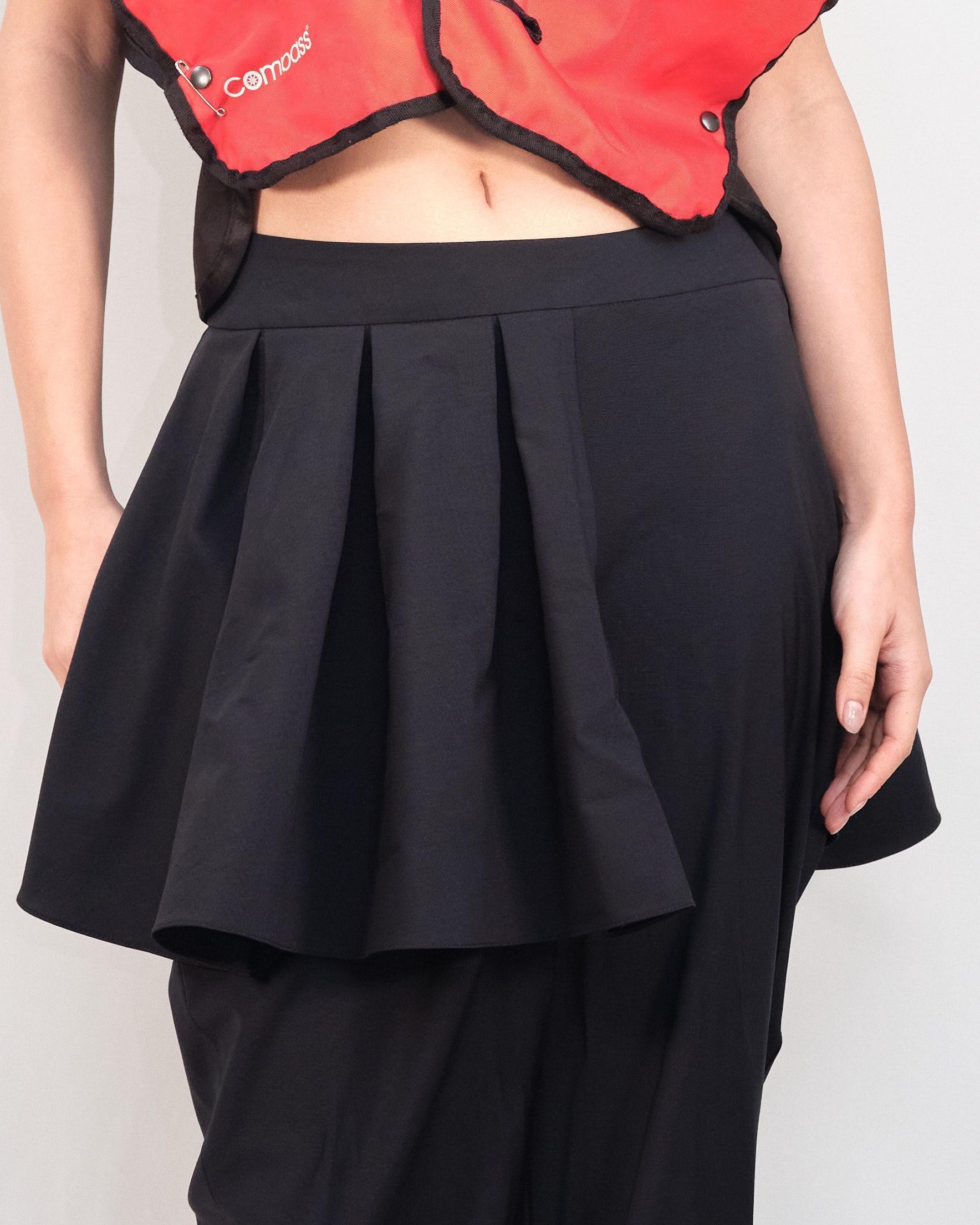 A woman wearing a black skirt and a red vest with the word cancer on it