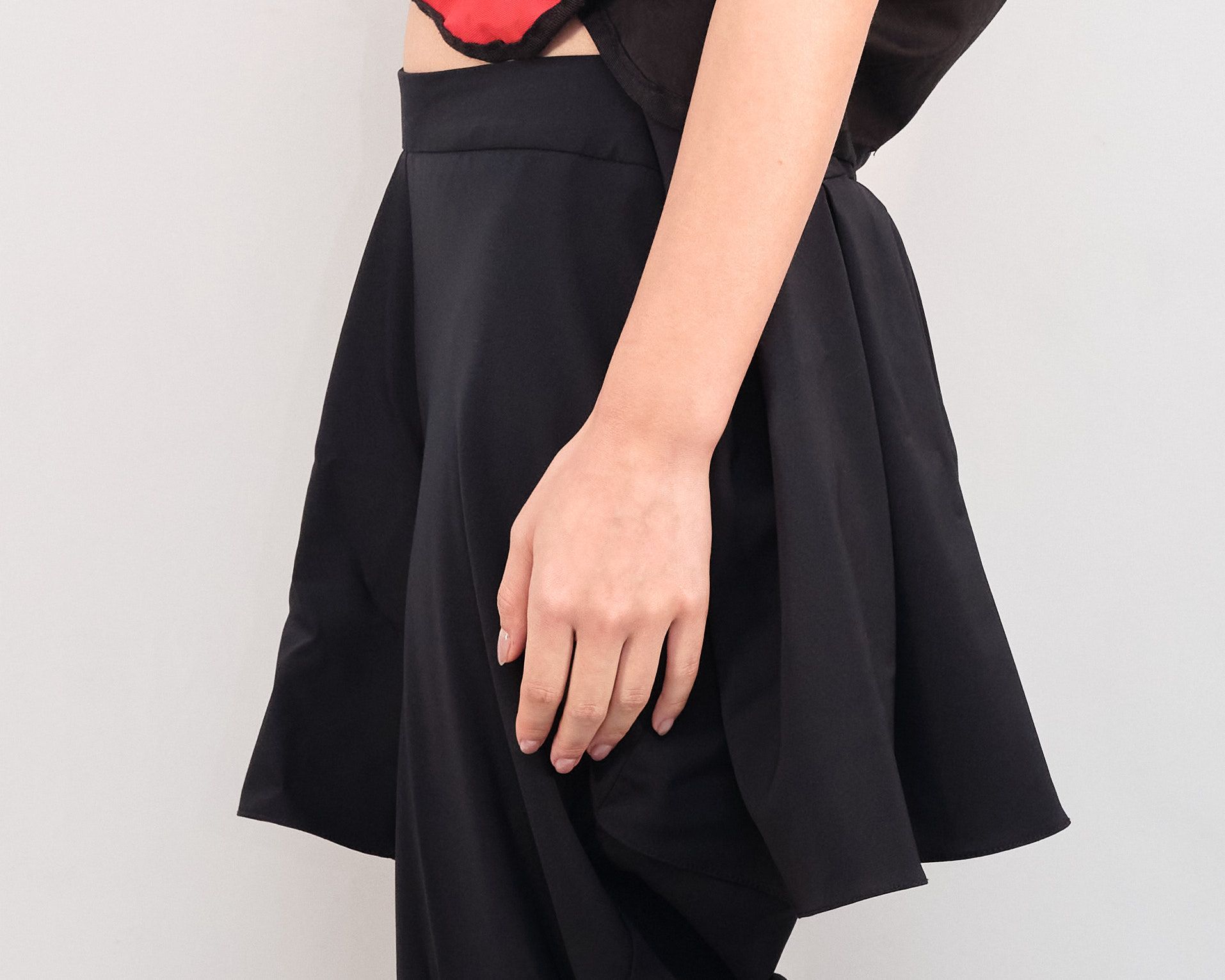 A woman wearing a black skirt has her hand on her knee