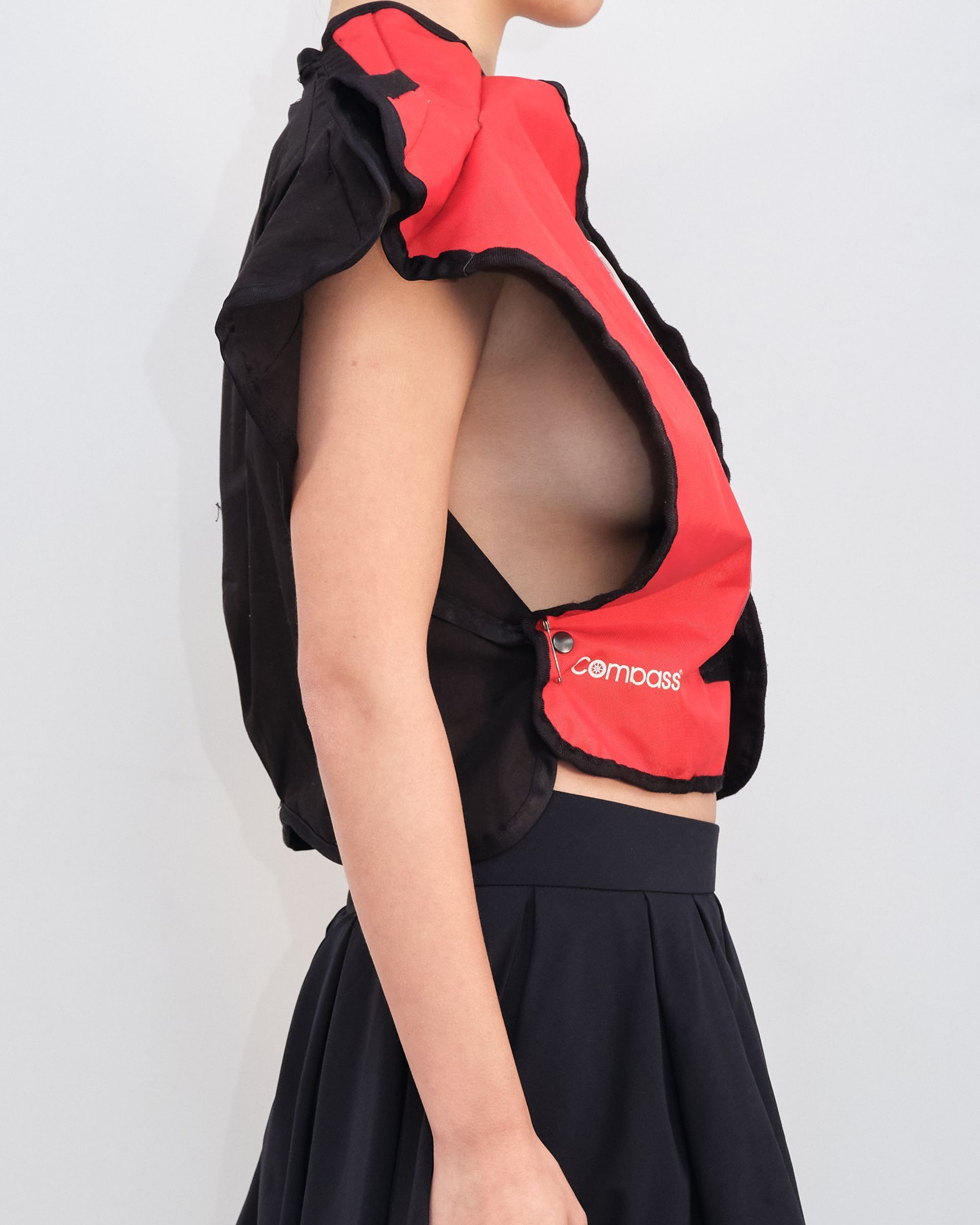 A woman wearing a red vest with the letter a on it