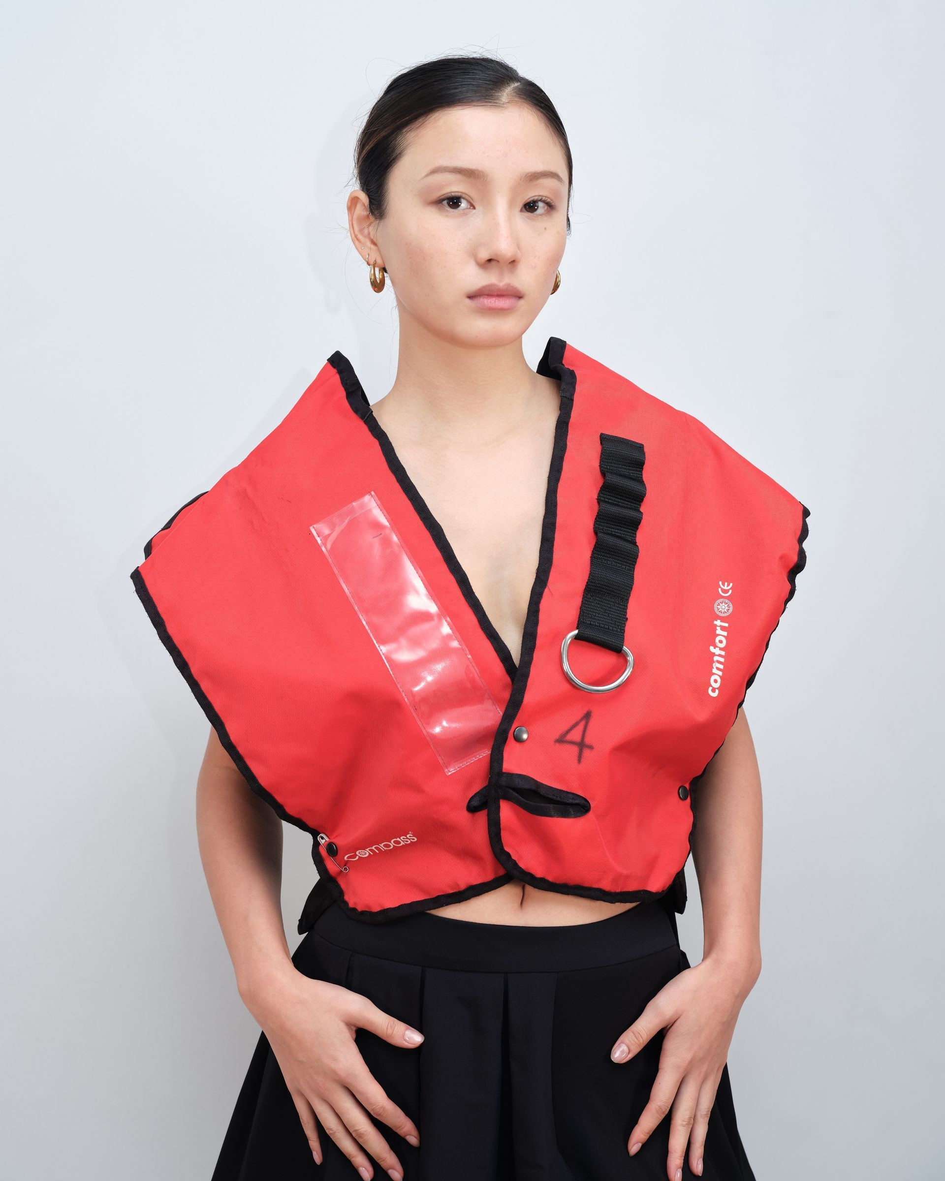 A woman wearing a red vest with the letter a on it