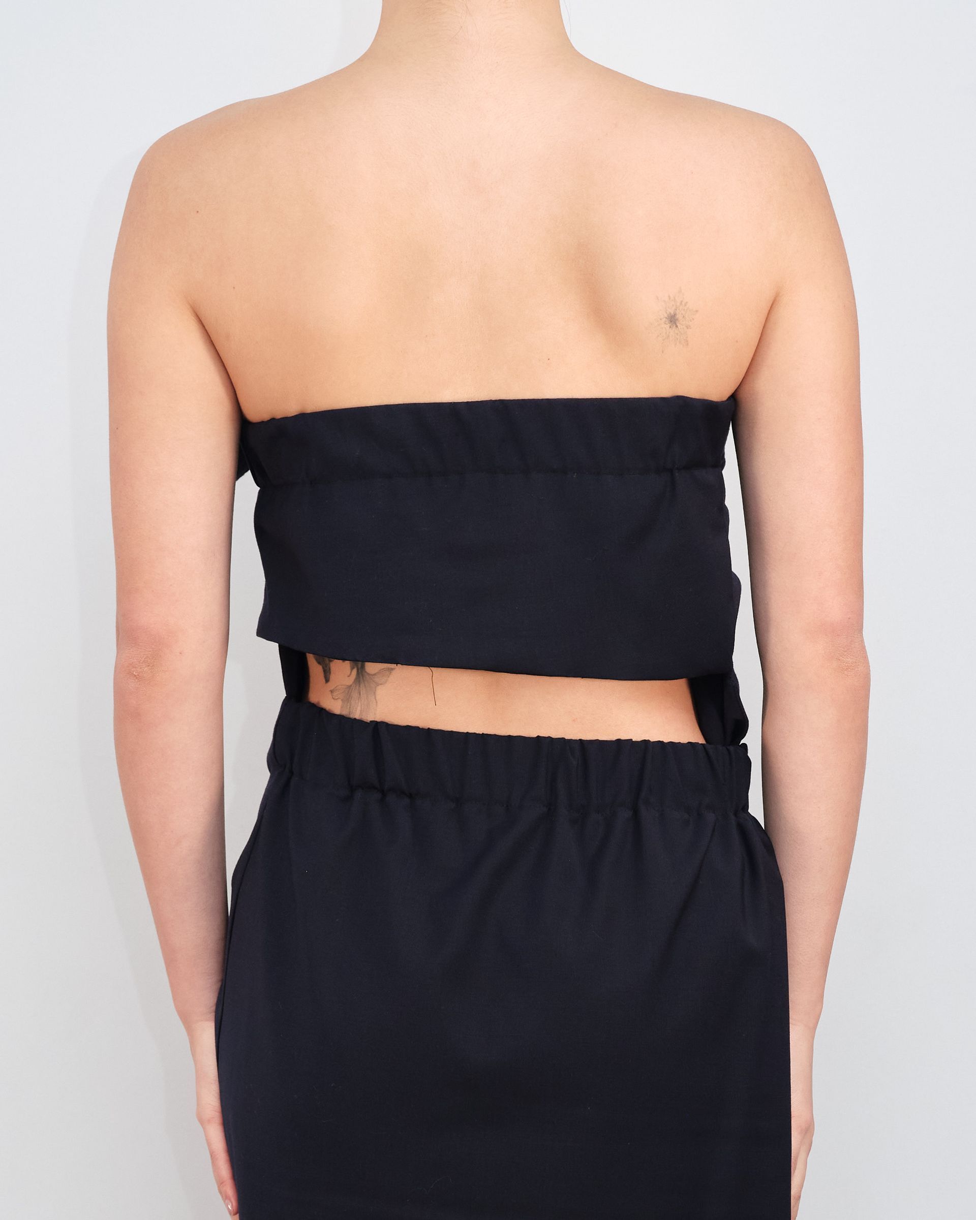 The back of a woman wearing a black strapless top