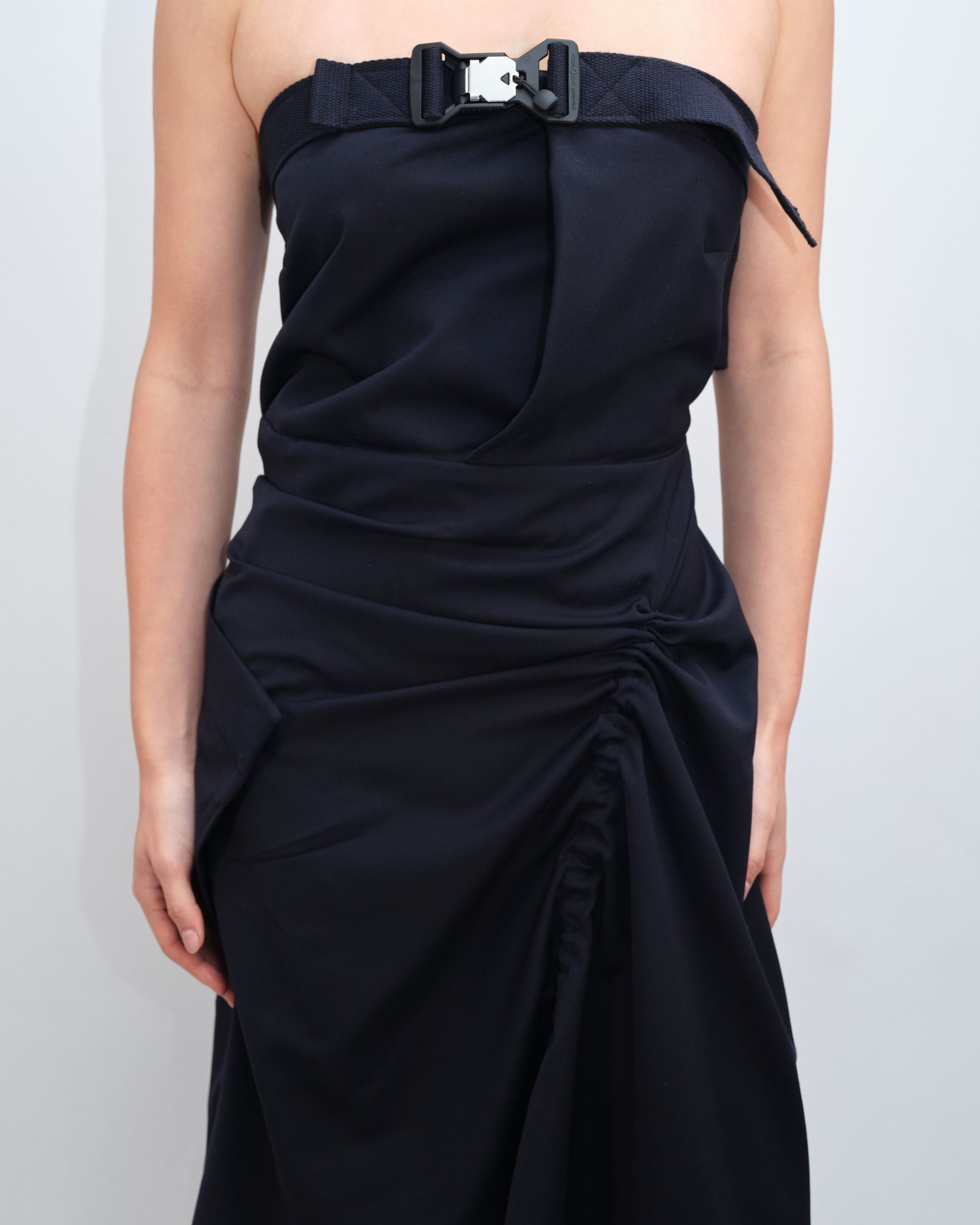 A woman is wearing a black strapless dress