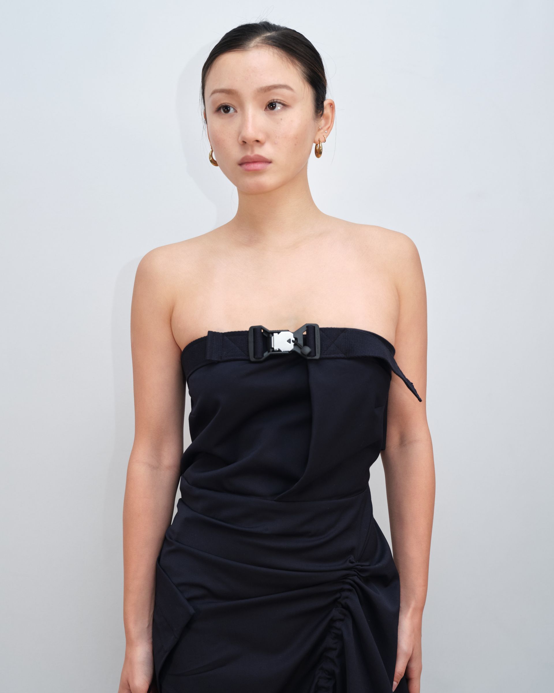 A woman is wearing a black strapless dress