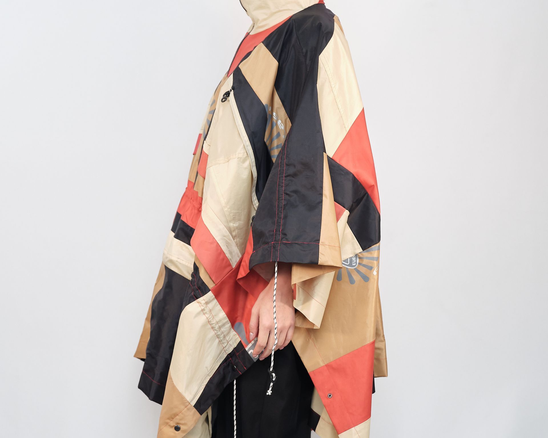 A woman is wearing a colorful poncho with a hood.