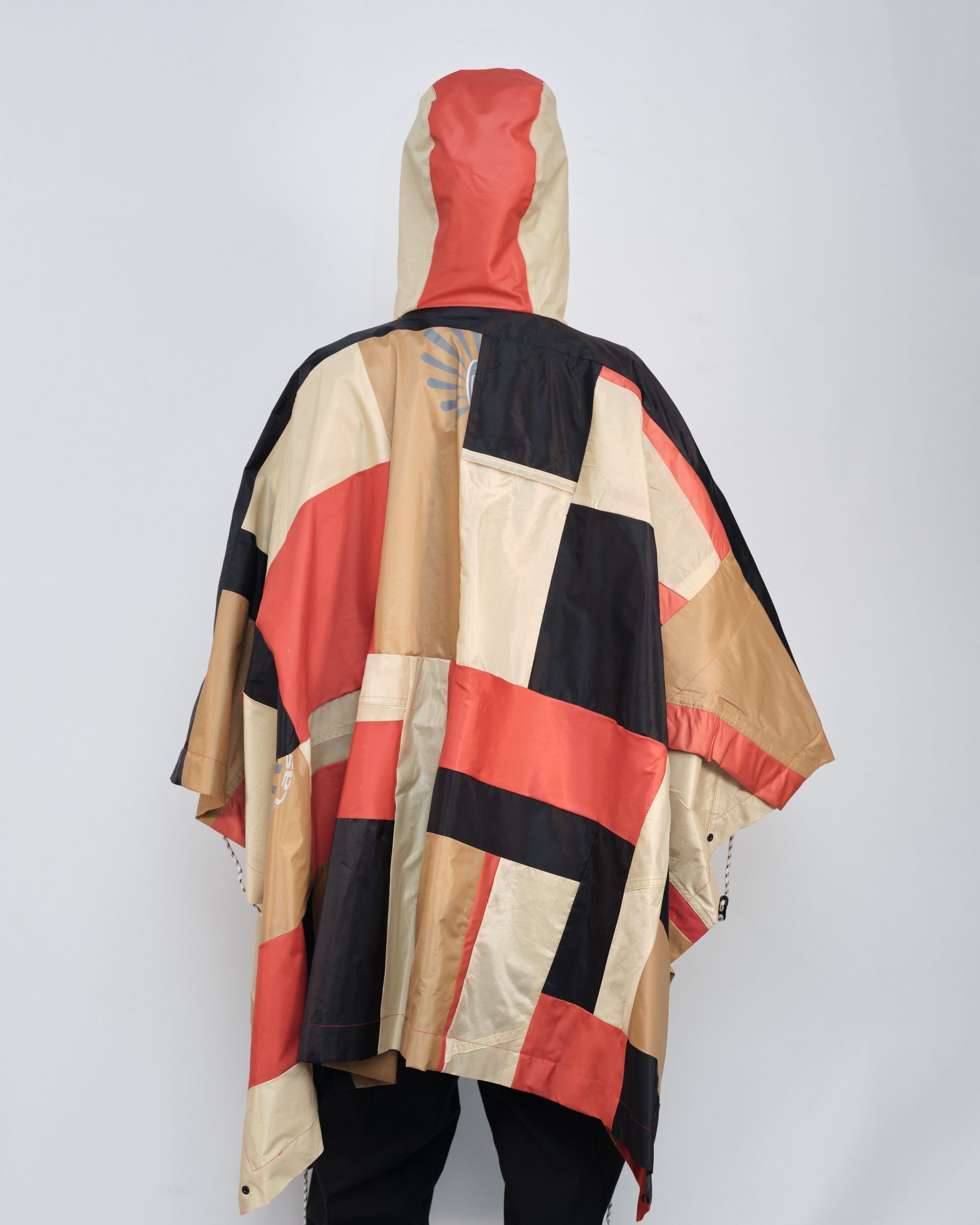 A person wearing a colorful poncho with a hood