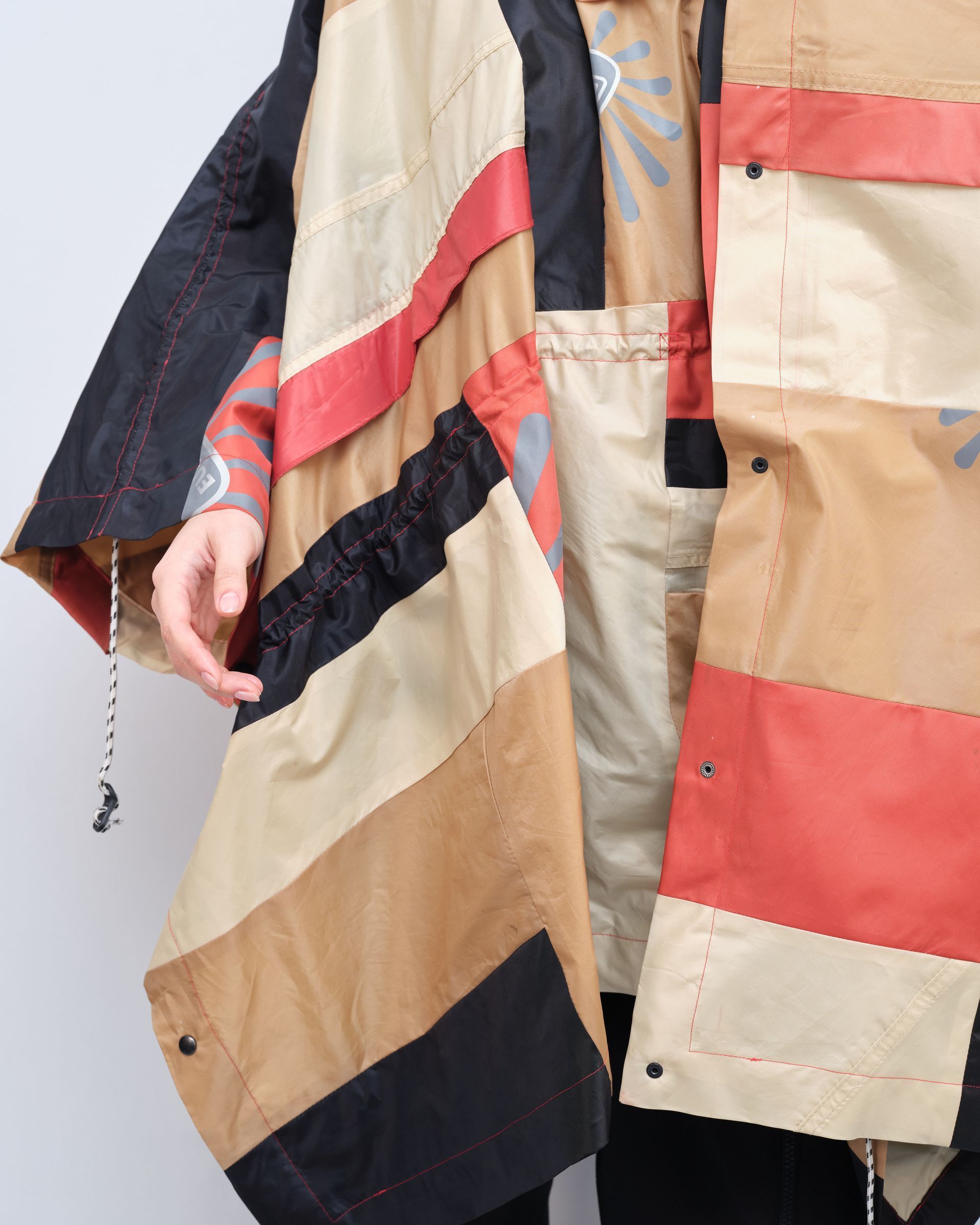 A person wearing a striped poncho with a hood