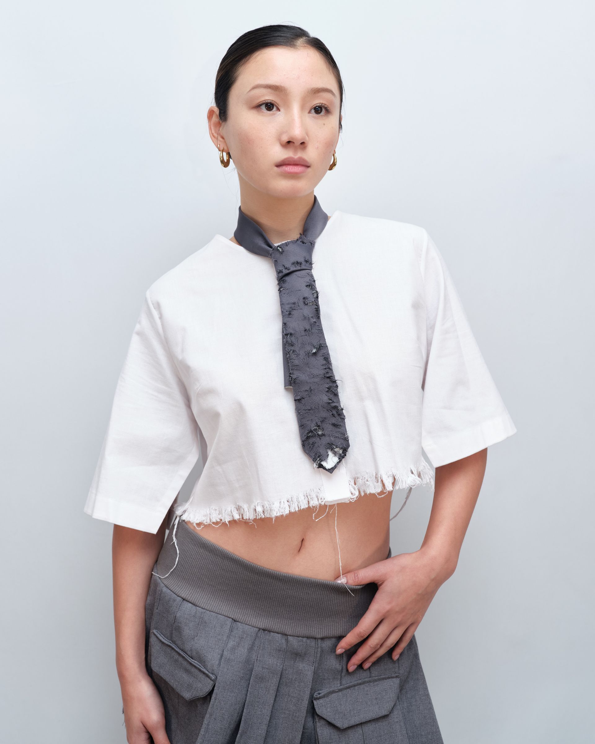 A woman wearing a tie and a crop top