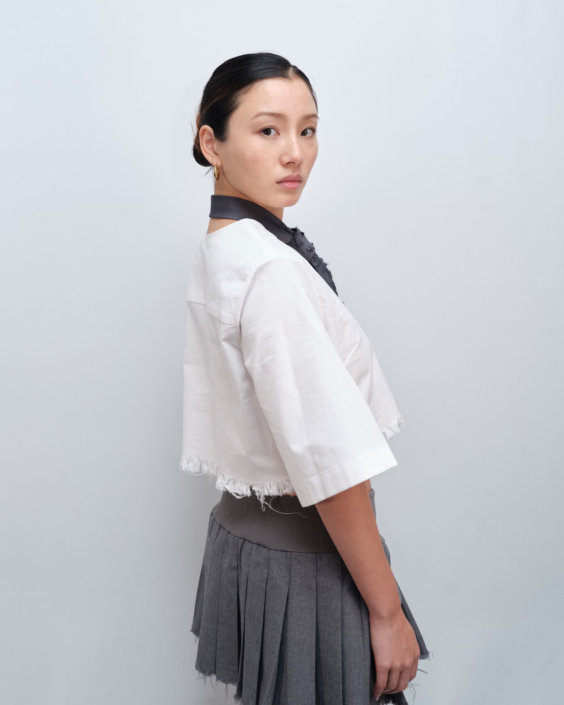 A woman wearing a tie and a crop top
