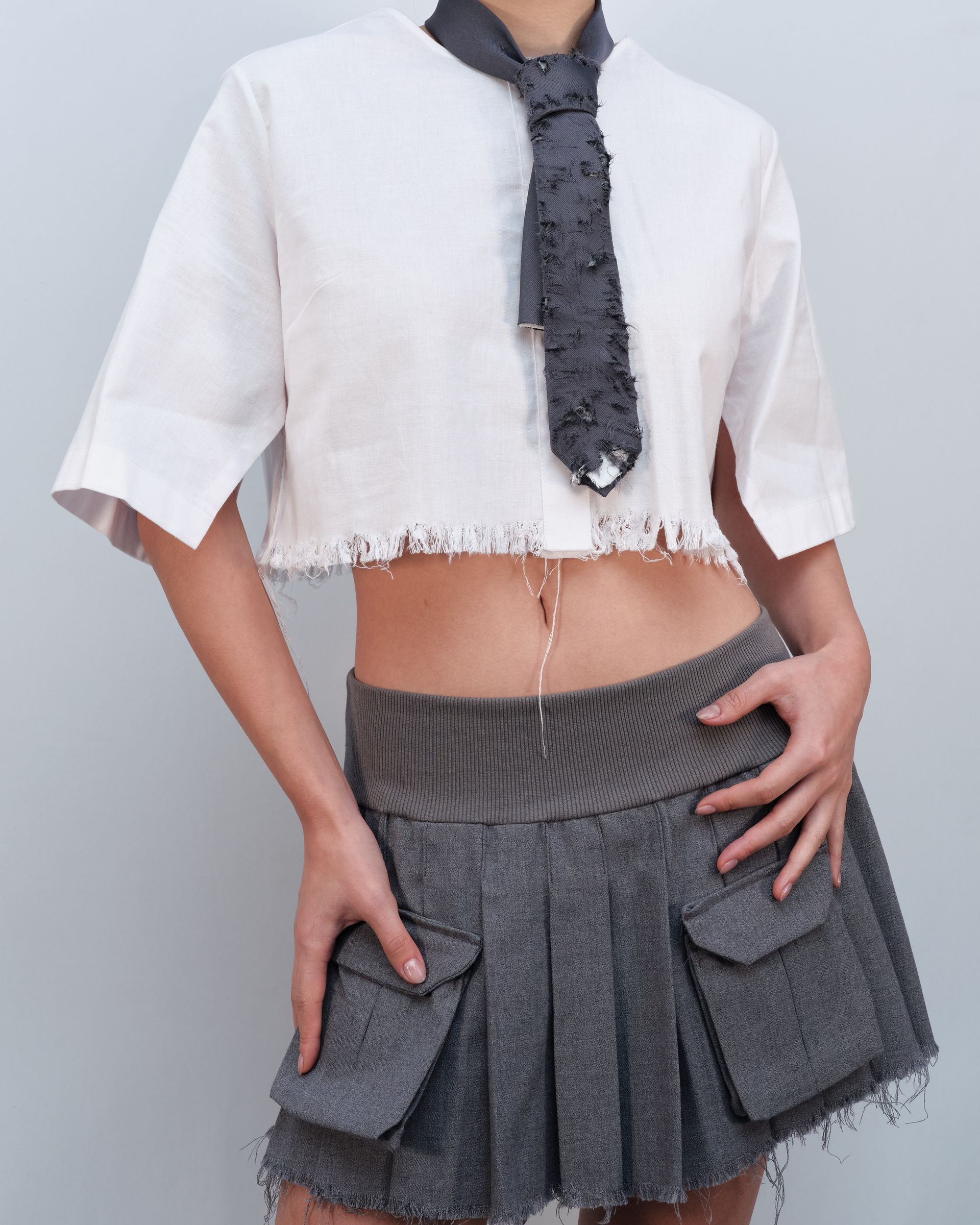 A woman wearing a tie and a crop top