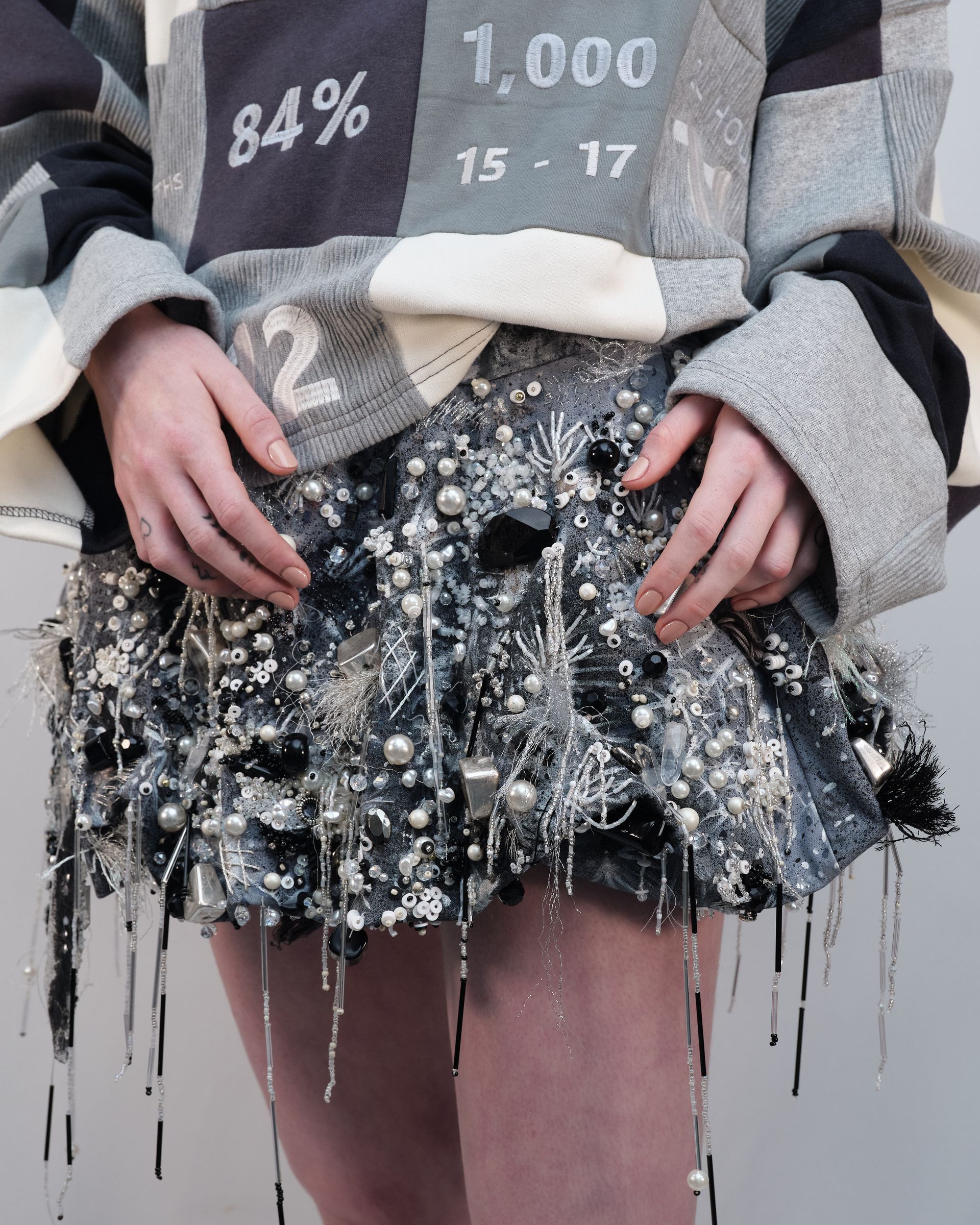 A person wearing a sweater that says 84% on it