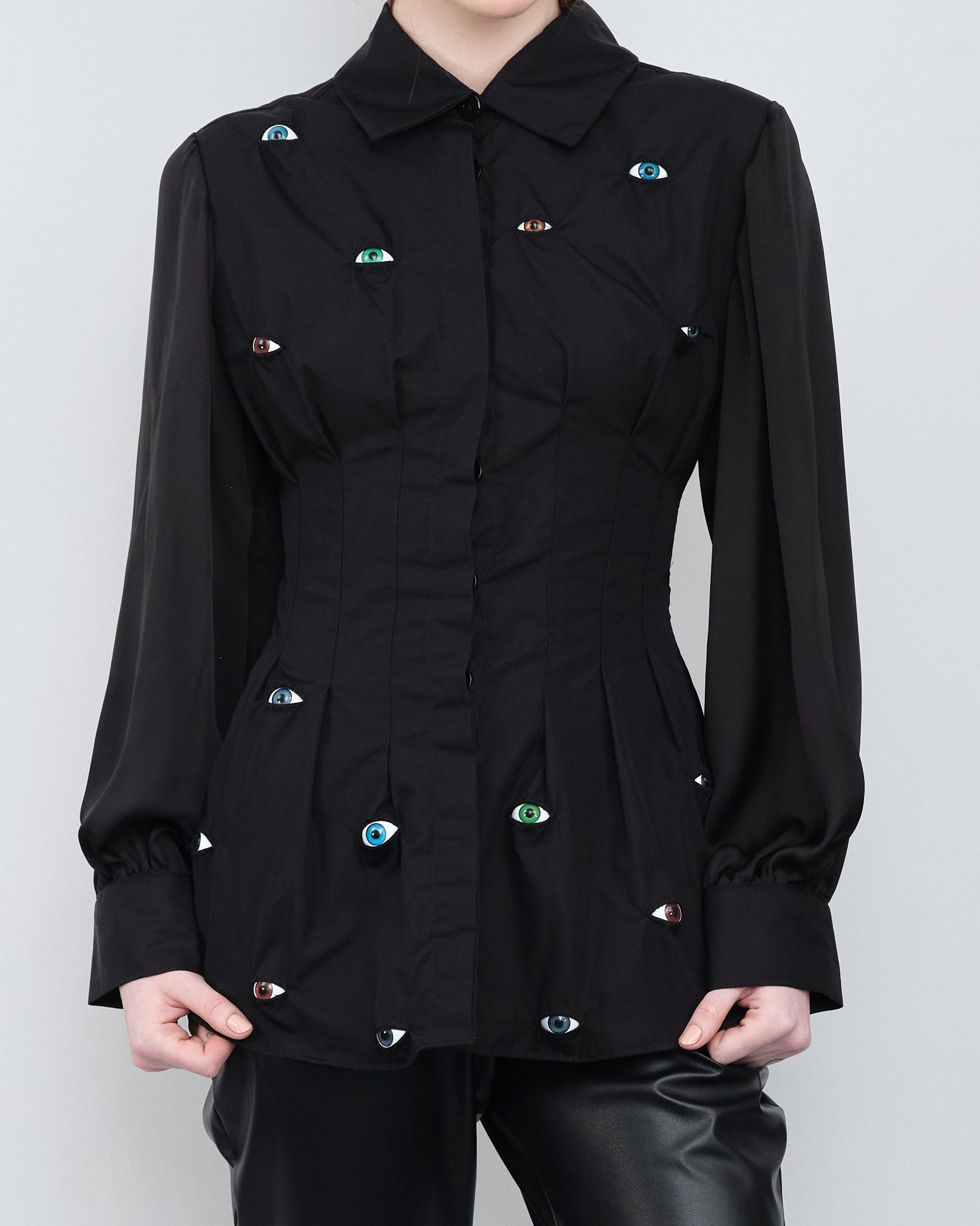 A woman wearing a black shirt with rhinestones on it