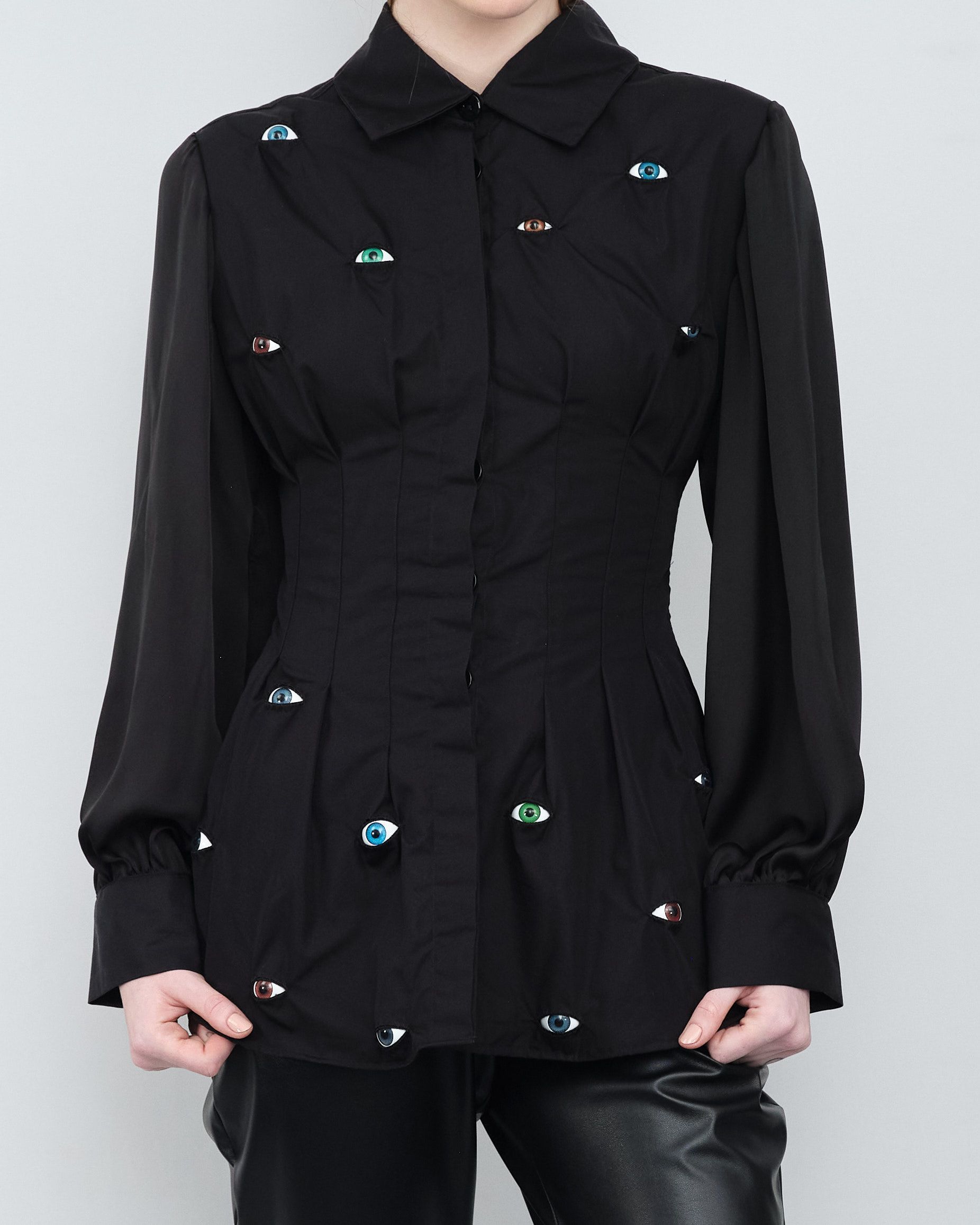 A woman wearing a black shirt with rhinestones on it