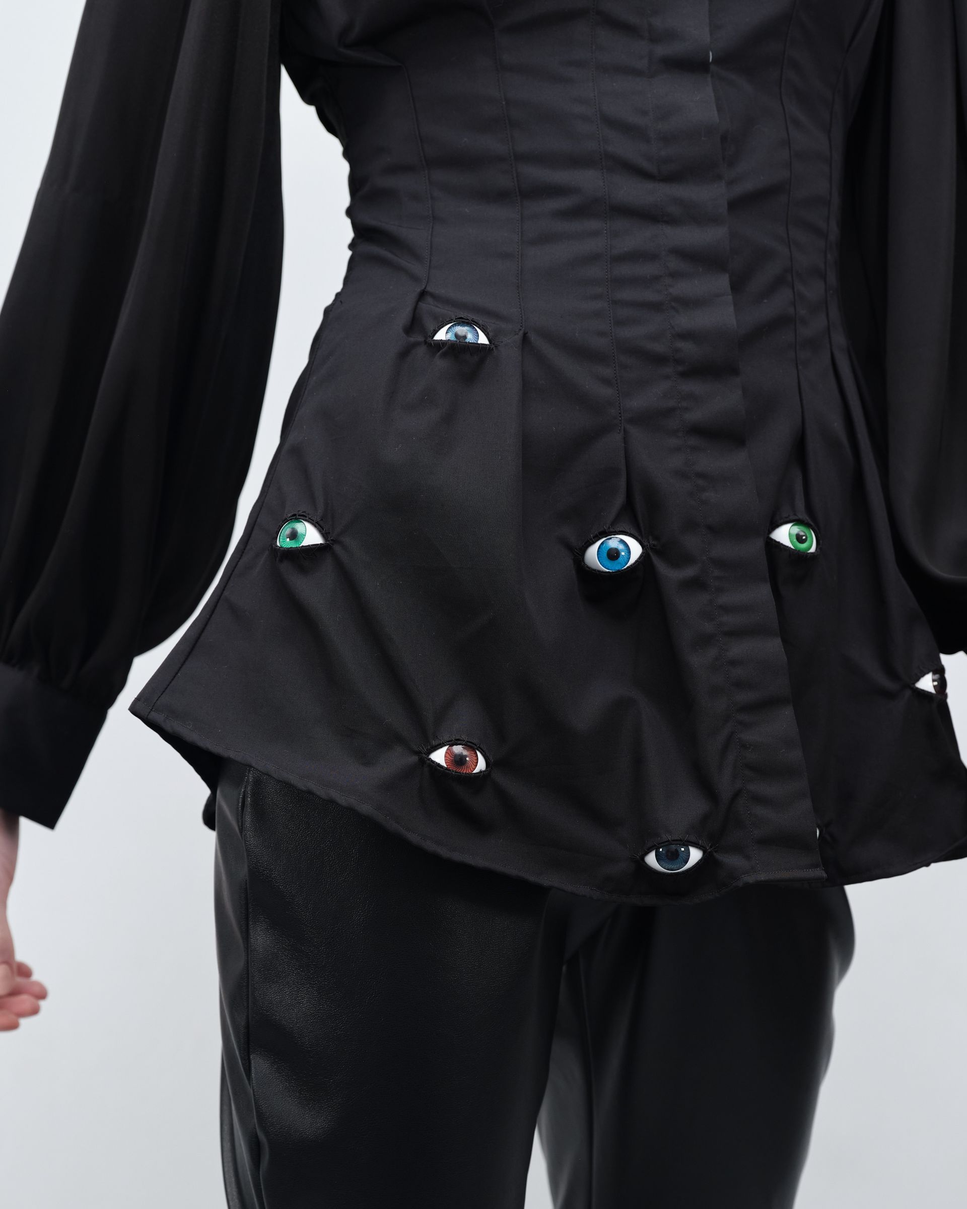 A woman wearing a black shirt with eyes on it