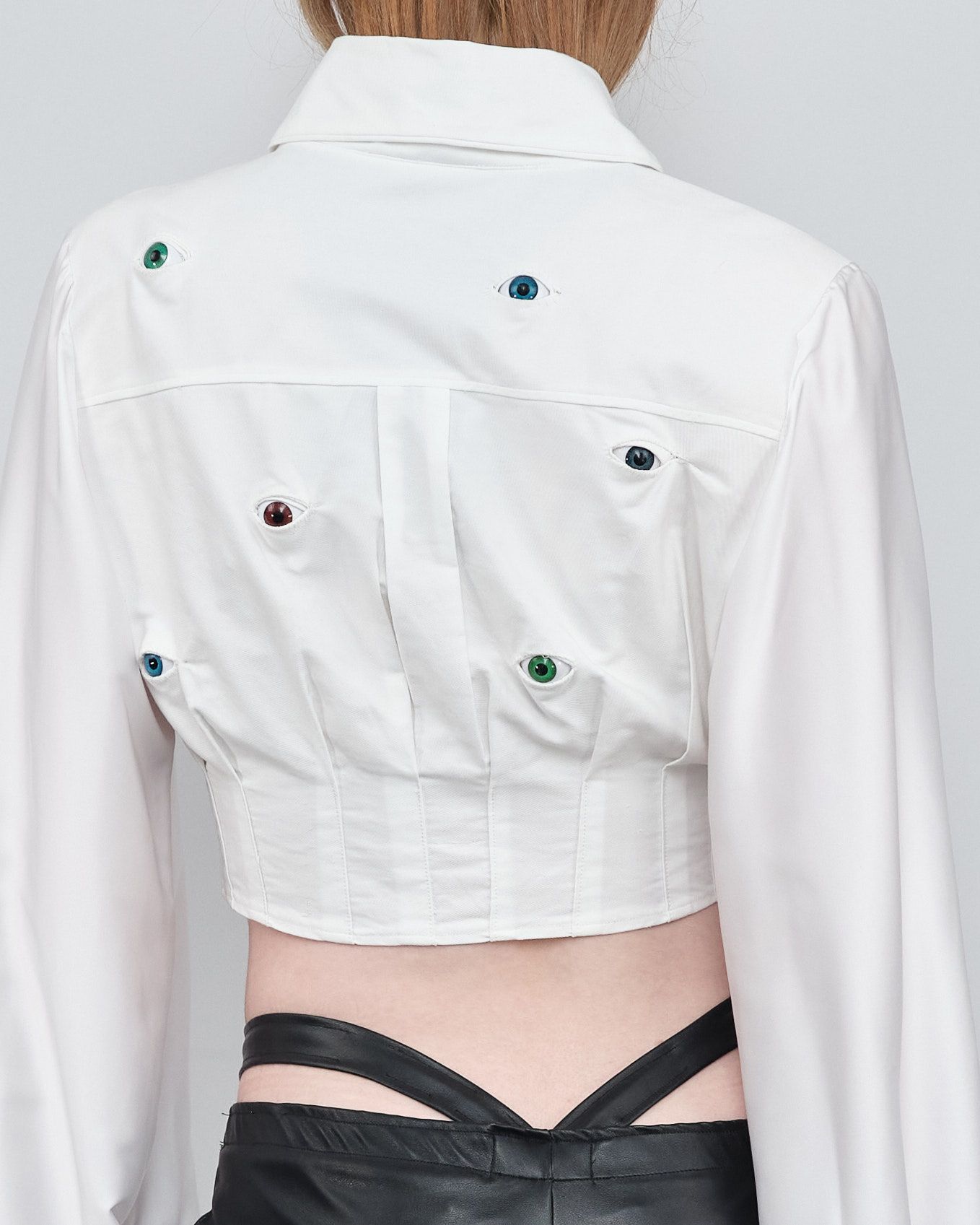 A woman wearing a white crop top and black shorts