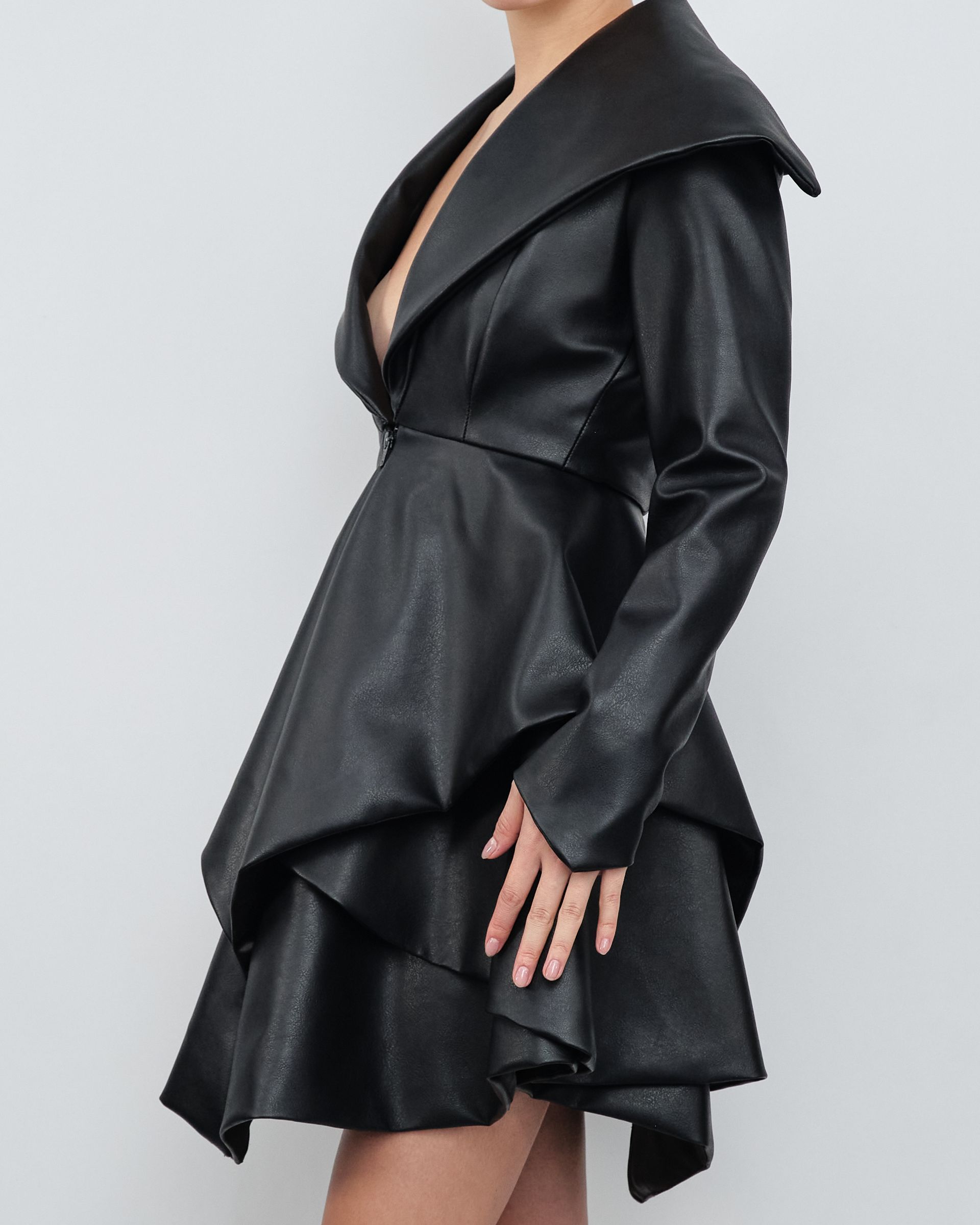 A woman is wearing a black dress with a plunging neckline