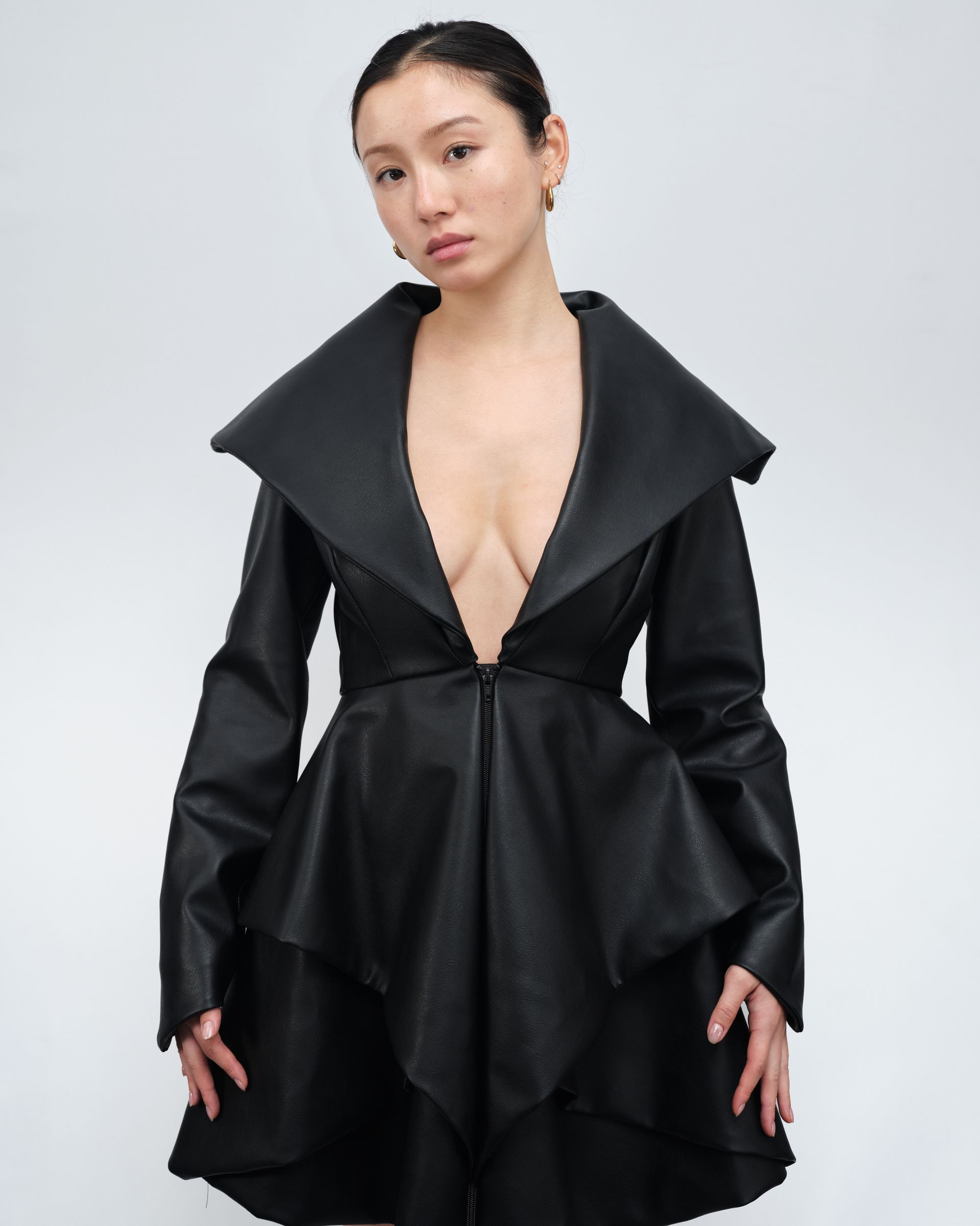 A woman is wearing a black dress with a plunging neckline