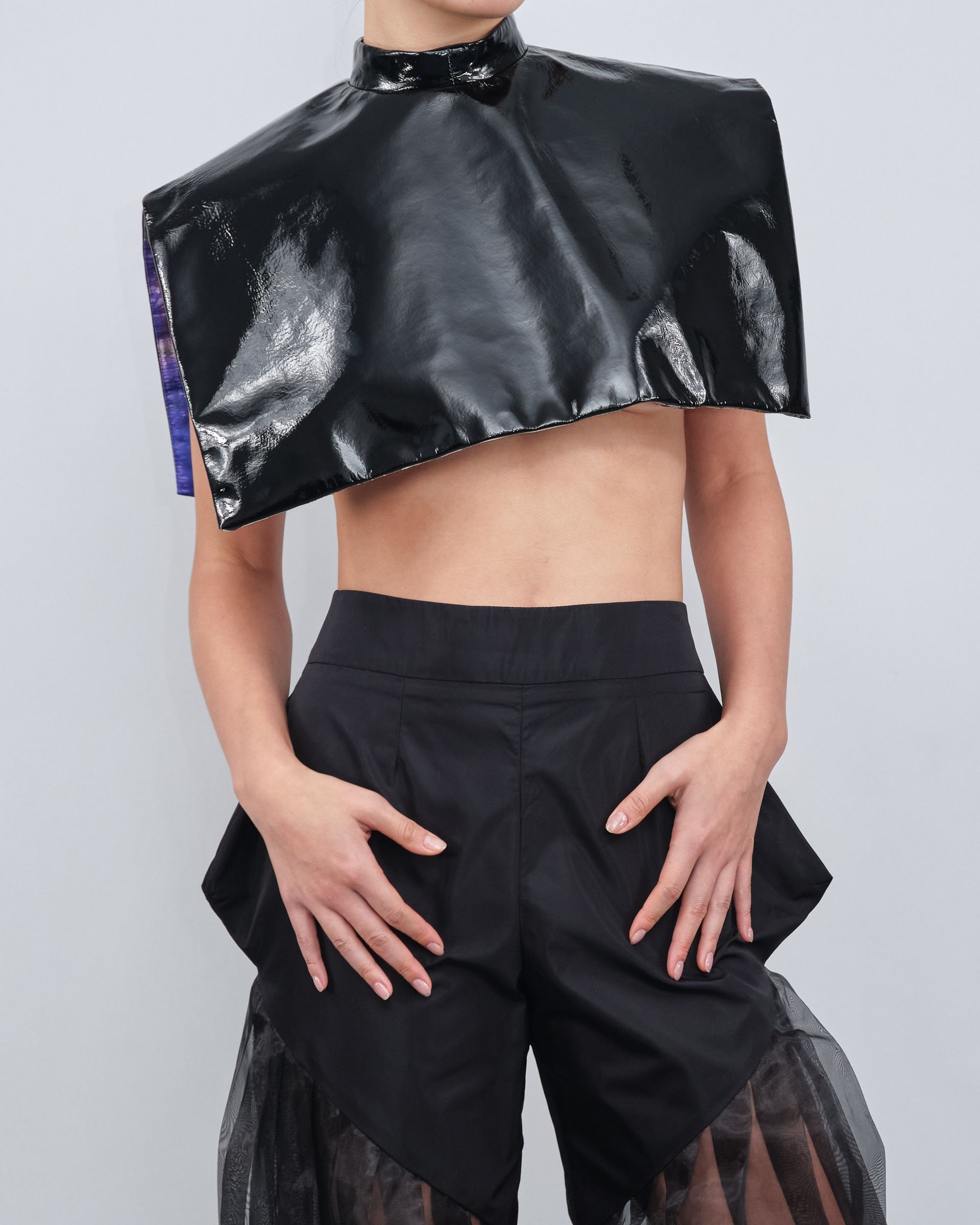 A woman wearing a black crop top and black shorts