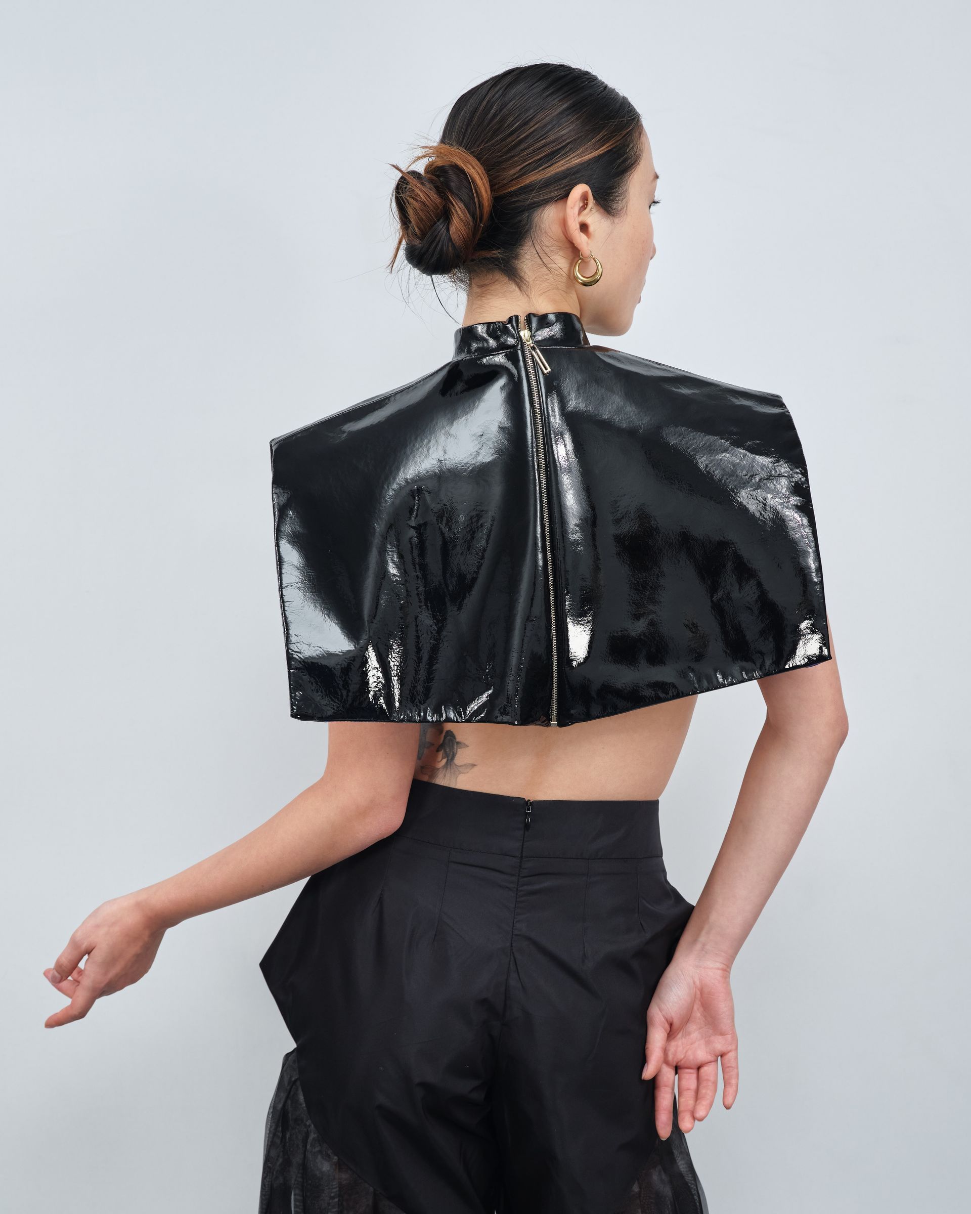 The back of a woman wearing a black top and black pants