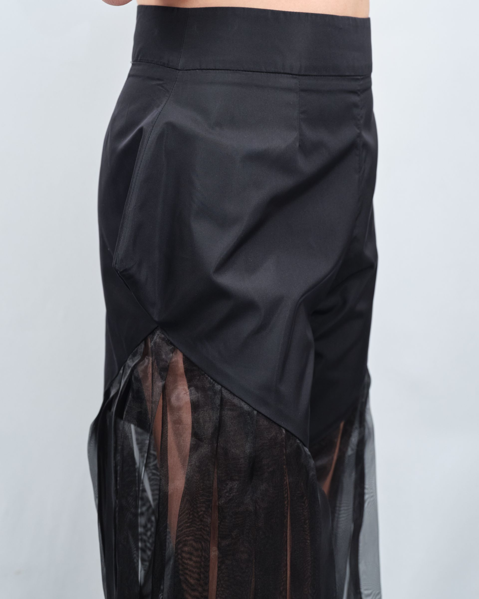 A woman is wearing a black skirt with a sheer side