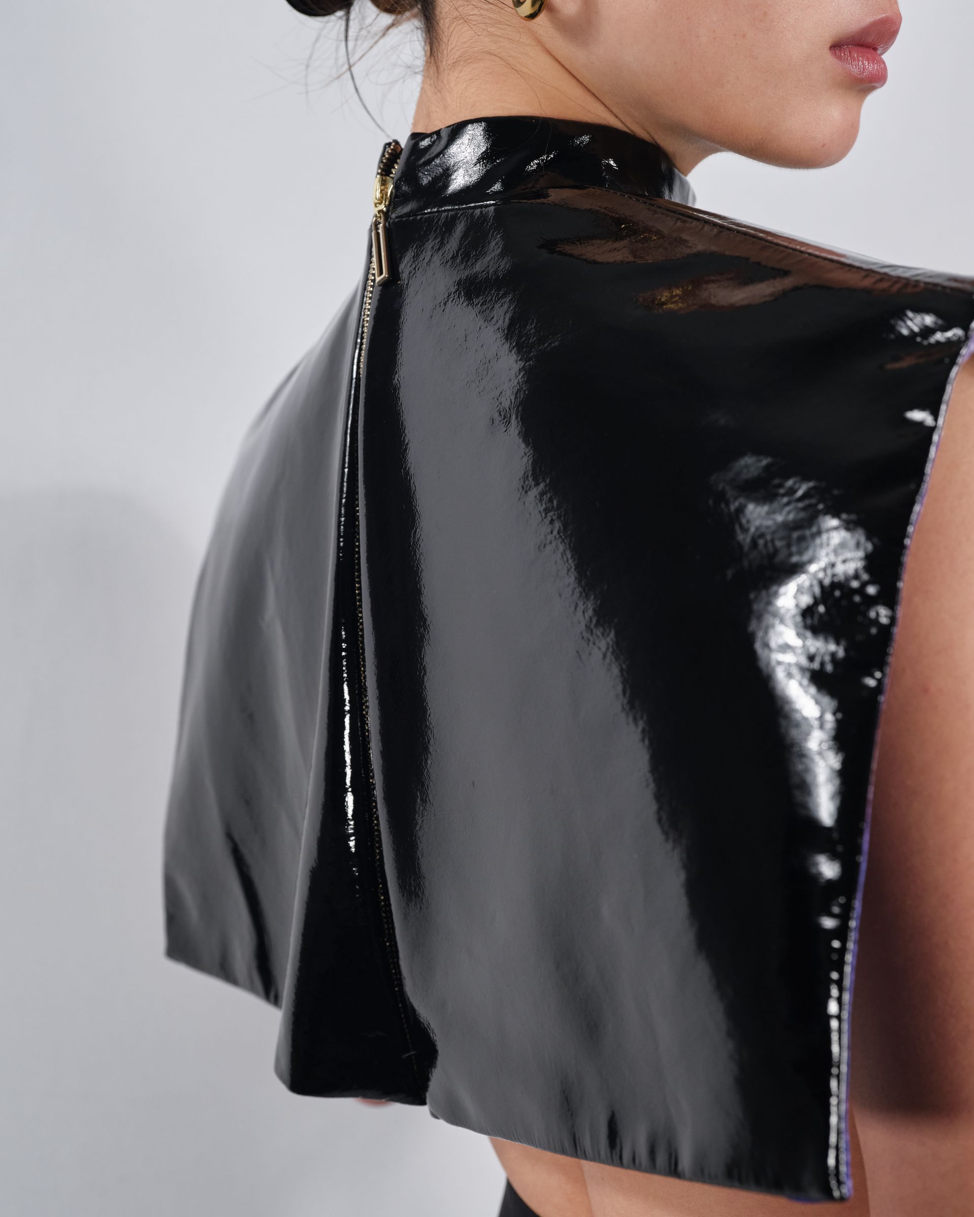 A woman wearing a black cape with a zipper on the back
