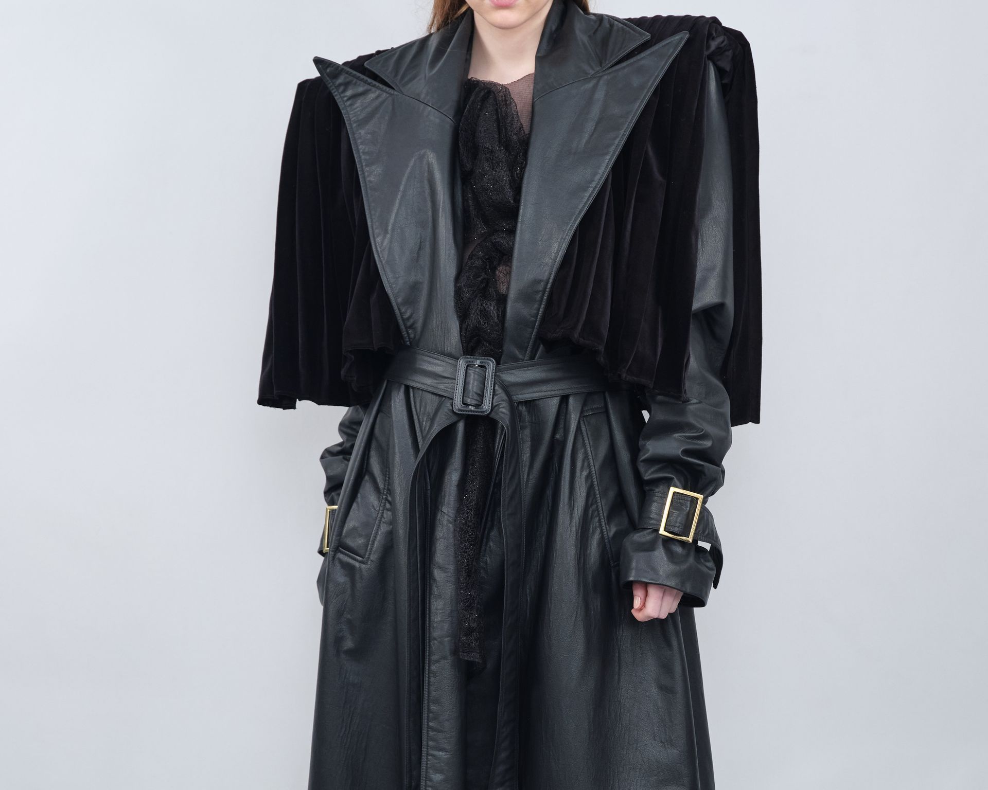 A woman is wearing a black leather coat with a fur cape.