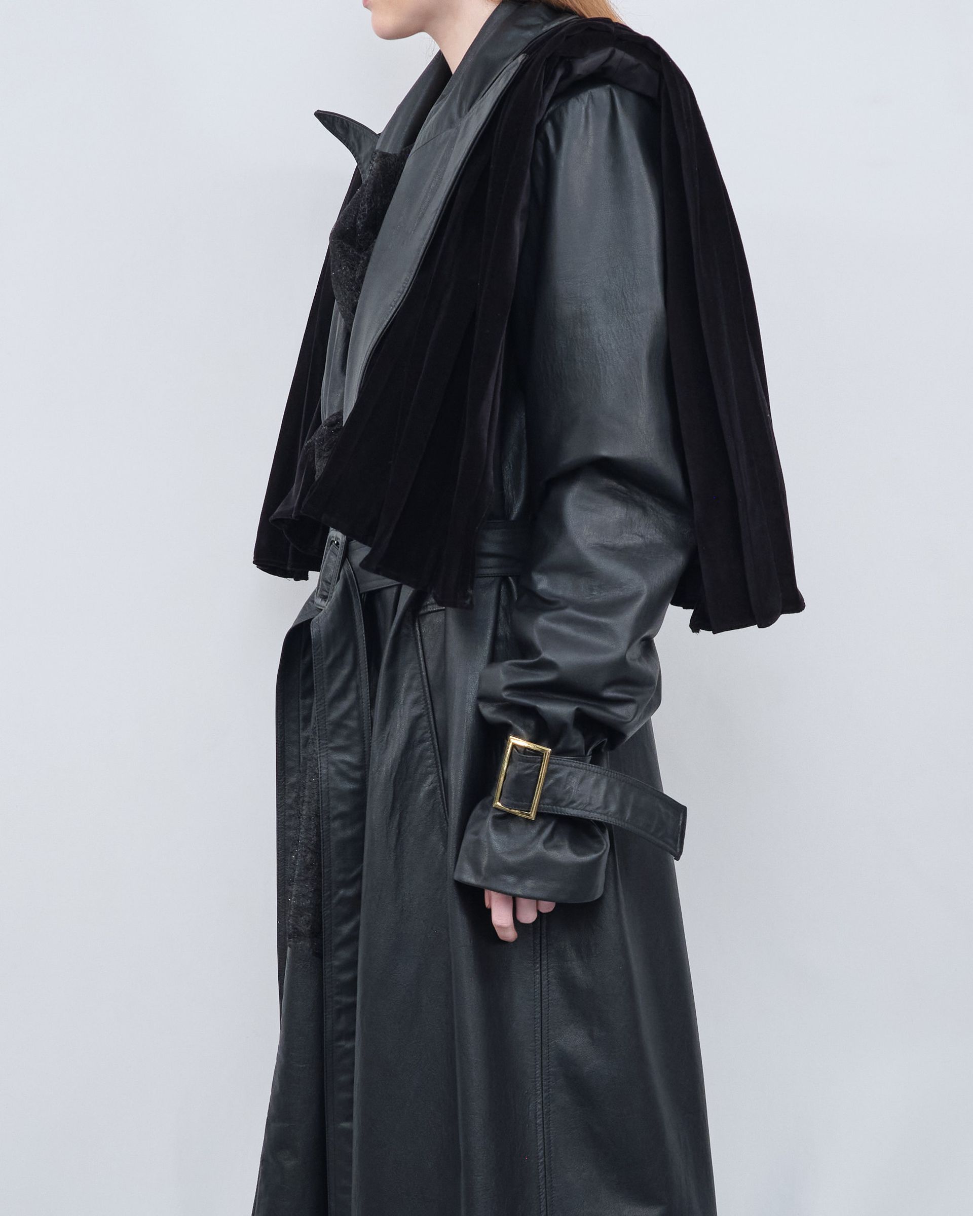 A woman wearing a black leather coat with a fur collar